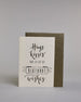Glückwunschkarte auf Englisch zum Geburtstag mit der Aufschrift "Hugs kisses and a lot of BIRTHDAY wishes" in schwarzer Schrift auf hellem Hintergrund. Die ersten zwei Zeilen, welche jeweils das Wort "Hugs" und "kisses" beinhaltet sind in der gleichen etwas dickeren schwarzen Schreibschrift gestaltet, darunter "AND A LOT OF" in einer dünnen geraden Schrift, darunter das Wort "BIRTHDAY" ist in dünn geschriebenen Großbuchstaben in einem gezeichneten Banner hervorgehoben, darunter dann noch in der gleichen Sc…