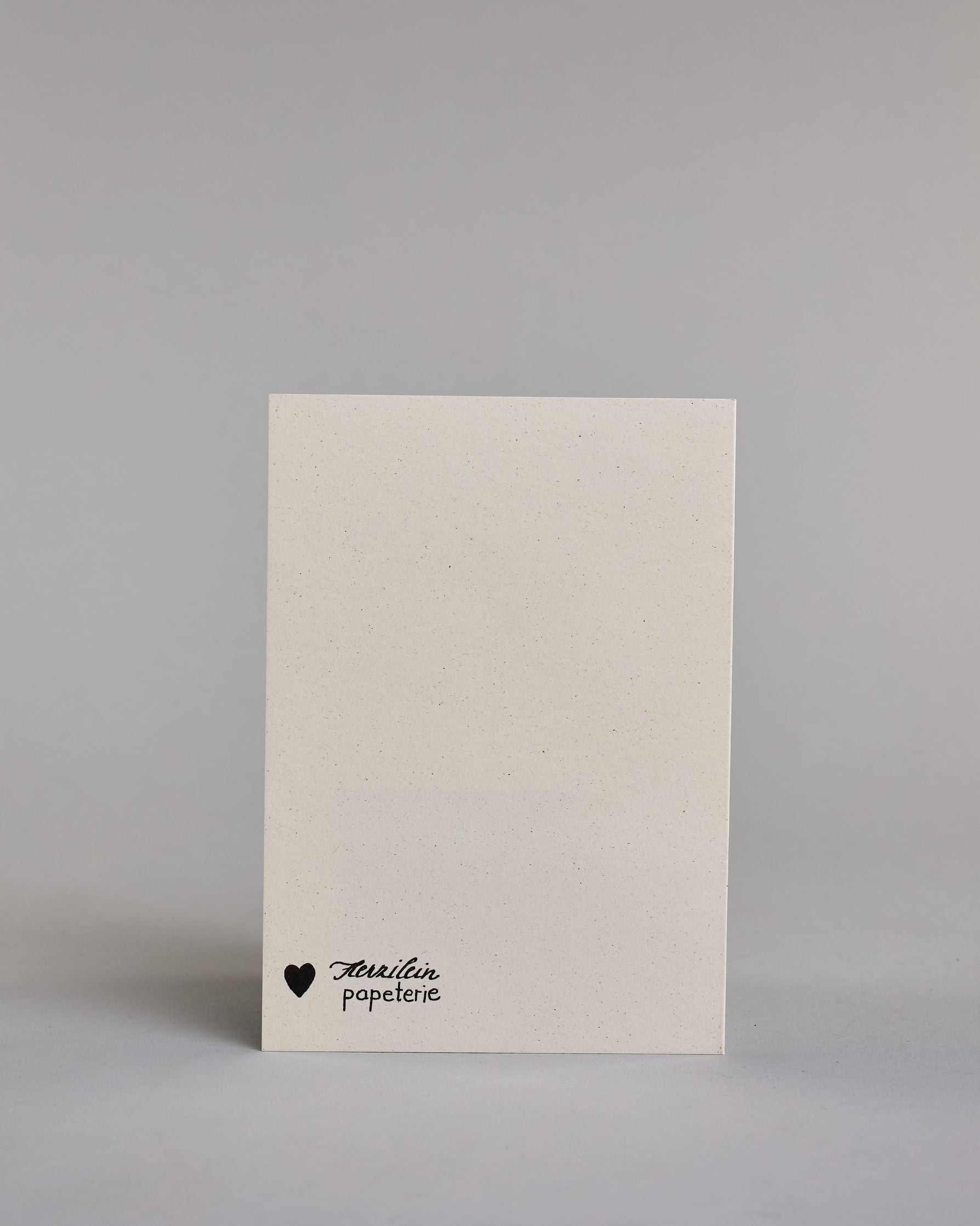 Glückwunschkarte auf Englisch zum Geburtstag mit der Aufschrift "Age ist just a number congratulations" in schwarzer, goldakzentuierter Schrift auf hellem Hintergrund. Die Zeilen sind wiefolgt aufgeteilt: "AGE" in großen Blockbuchstaben, darunter "is just a" in dünner geschwungener Schrift, darunter "number" in dicker geschwungener Schrift, darunter "congratulations" wieder in dünner geschwungener Kalligrafieschrift. Dazu ein grün-goldenes handgeschöpftes Kuvert. #4