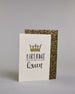 Glückwunschkarte auf Englisch zum Geburtstag mit schwarzer Kalligrafieaufschrift "Birthday Queen", mit einer prunkvollen goldenen und goldglitzernden Krone. Der Text ist übereinander geschrieben mit einer horizontalen goldverzierten Linie dazwischen. Das "Birthday" ist in Blockbuchstaben und das "Queen" in geschwungener Schreibschrift auf hellem Hintergrund. Dazu ein grün-goldenes handgeschöpftes Kuvert. #3
