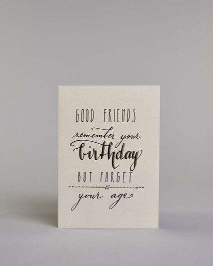 Glückwunschkarte auf Englisch zum Geburtstag mit schwarzer Kalligrafieaufschrift "Good Friends remember your brithday but forget your age" auf hellem Hintergrund. Die Zeilen sind wiefolgt aufgeteilt: "GOOD FRIENDS" in dünner gerader Kallirafieschrift, darunter "remember your" in dünner geschwungener Schreibschrift, darunter "birthday" in dicker geschwungenen Schreibschrift, darunter "but forget" in dünner, gerader Kalligrafieschrift, darunter eine horizontale verspielte Trennlinie, darunter "your age" in g…