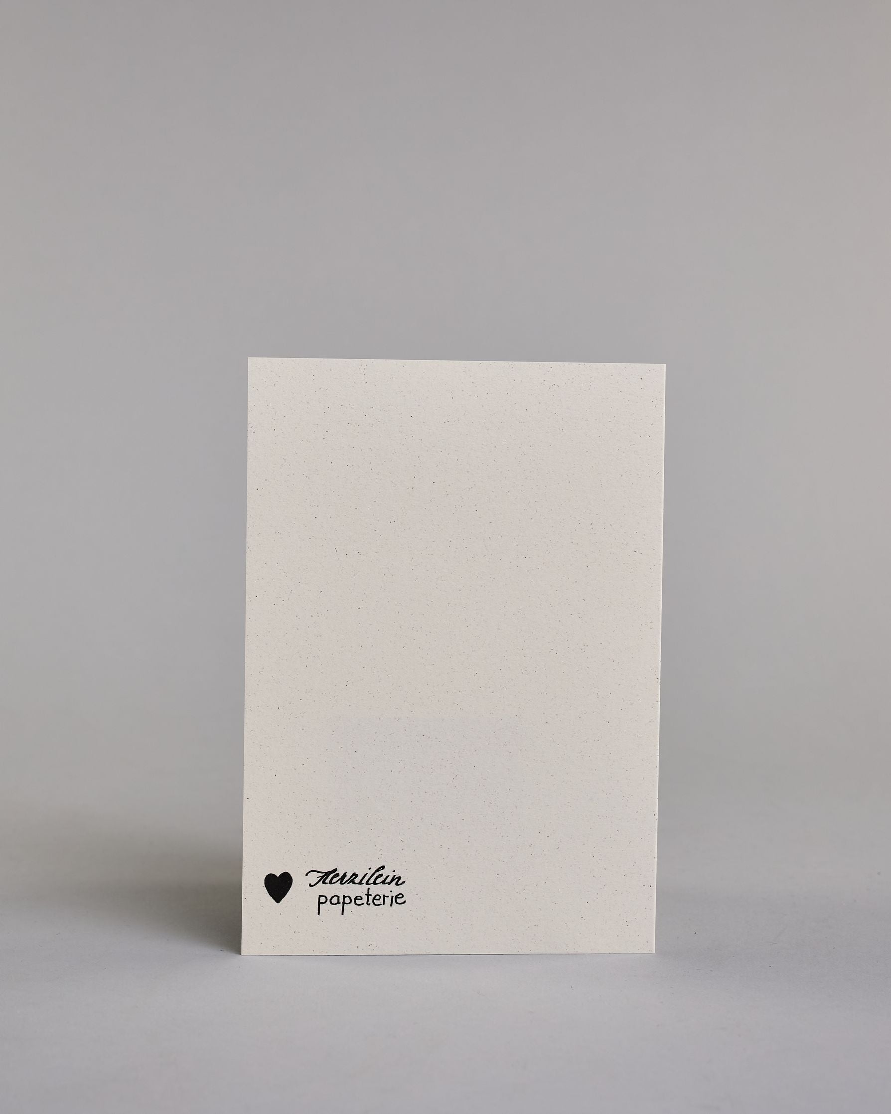 Glückwunschkarte zum Geburtstag mit schwarzer Kalligrafieaufschrift "siebzig Glückwunsch" auf hellem Hintergrund. Die ausgeschriebene Zahl ist leicht aufsteigend in geschwungener, goldverzierter Schreibschrift gestaltet und das Wort "GLÜCKWUNSCH" darunter leicht nach rechts versetzte ist in dünner, gerader Kalligrafieschrift geschrieben. Dazu ein gold-weißes handgeschöpftes Kuvert. #4