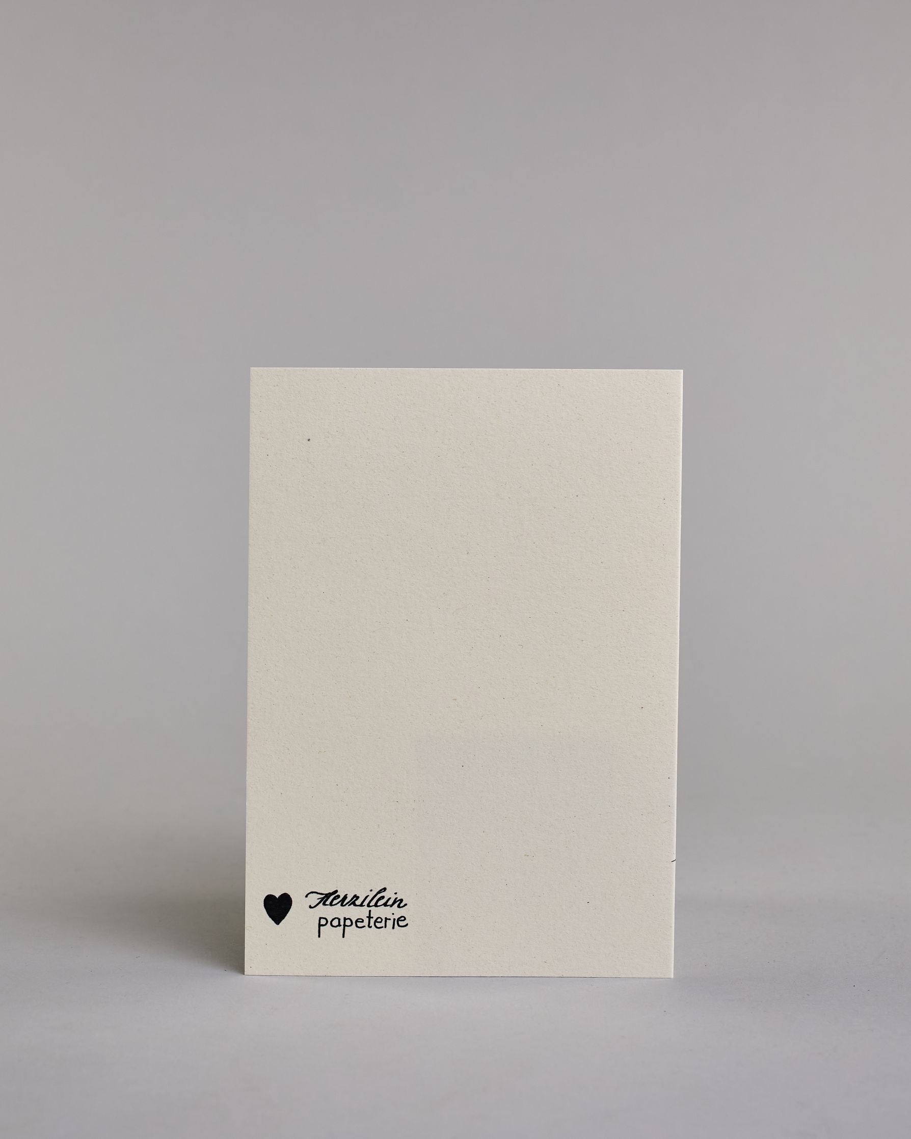 Glückwunschkarte zum Geburtstag mit schwarzer Kalligrafieaufschrift "Das Alter ist doch irrelefant!", mit einem gezeichneten Elefanten mit einer Krone auf dem Kopf, der Kofetti aus dem Rüssel pustet auf hellem Hintergrund. Oben steht in dünner gerader Kalligrafieschrift "DAS ALTER IST DOCH", darunter "irrelefant" in geschwungener Handschrift mit einem "f" statt einem "v" für das Wortspiel. Darunter ist der Elefant dessen Kopf von der linken Seite auf die Karte kommt. Dazu ein grün-goldenes handgeschöpftes…