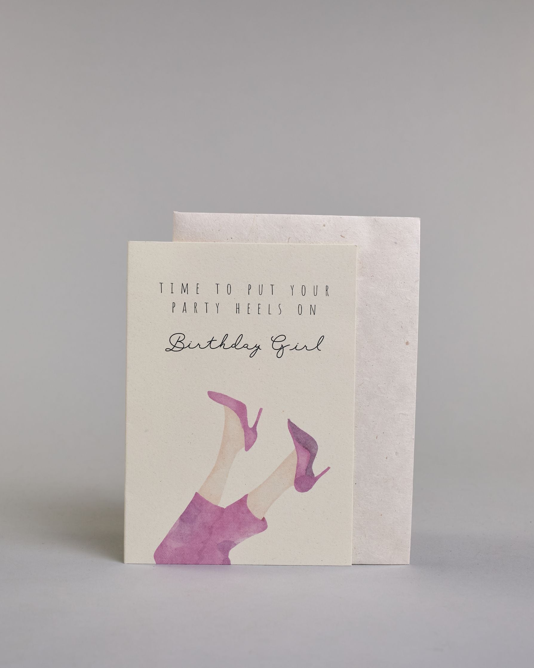 Glückwunschkarte auf Englisch zum Geburtstag mit schwarzer Kalligrafieaufschrift "time to put your party heels on Birthday girl", mit genzeichneten Damenbeinen die mit einer pinken Hose bedeckt sind und pinke Stöckelschuhe tragen auf hellem Hintergrund. Oben steht in drei Zeilen "TIME TO PUT YOUR", darunter "PARTY HEELS ON" beides in dünner gerader Kalligrafieschrift, darunter "Birthdaygirl" in geschwungener dünner Schreibschrift, darunter die Damenbeine. Dazu ein weißes handgeschöpftes Kuvert. #2