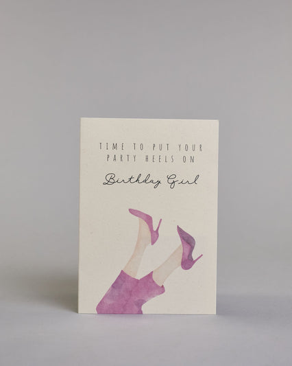 Glückwunschkarte auf Englisch zum Geburtstag mit schwarzer Kalligrafieaufschrift "time to put your party heels on Birthday girl", mit genzeichneten Damenbeinen die mit einer pinken Hose bedeckt sind und pinke Stöckelschuhe tragen auf hellem Hintergrund. Oben steht in drei Zeilen "TIME TO PUT YOUR", darunter "PARTY HEELS ON" beides in dünner gerader Kalligrafieschrift, darunter "Birthdaygirl" in geschwungener dünner Schreibschrift, darunter die Damenbeine. Dazu ein weißes handgeschöpftes Kuvert. #1