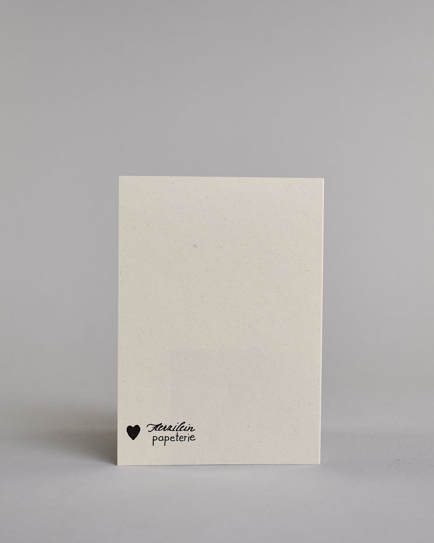 Glückwunschkarte zum Geburtstag mit Schwarzer Kalligrafieaufschrift "Für einen ganz besonderen Menschen Alles Liebe & Gute zum Geburtstag" auf hellem Hintergund. Aufgeteilt ist die Schrift wiefolgt: "FÜR EINEN GANZ" in dünner gerader Kalligrafieschrift, darunter "besonderen", darunter "Menschen beides in einer geschwungenen Schreibschrift, darunter mittig ein goldenen aufgeklebtes kleine Herz das links und rechts von horizonatlen Linien umgeben ist, darunter "ALLES LIEBE & GUTE ZUM" in dünner gerade Kallig…
