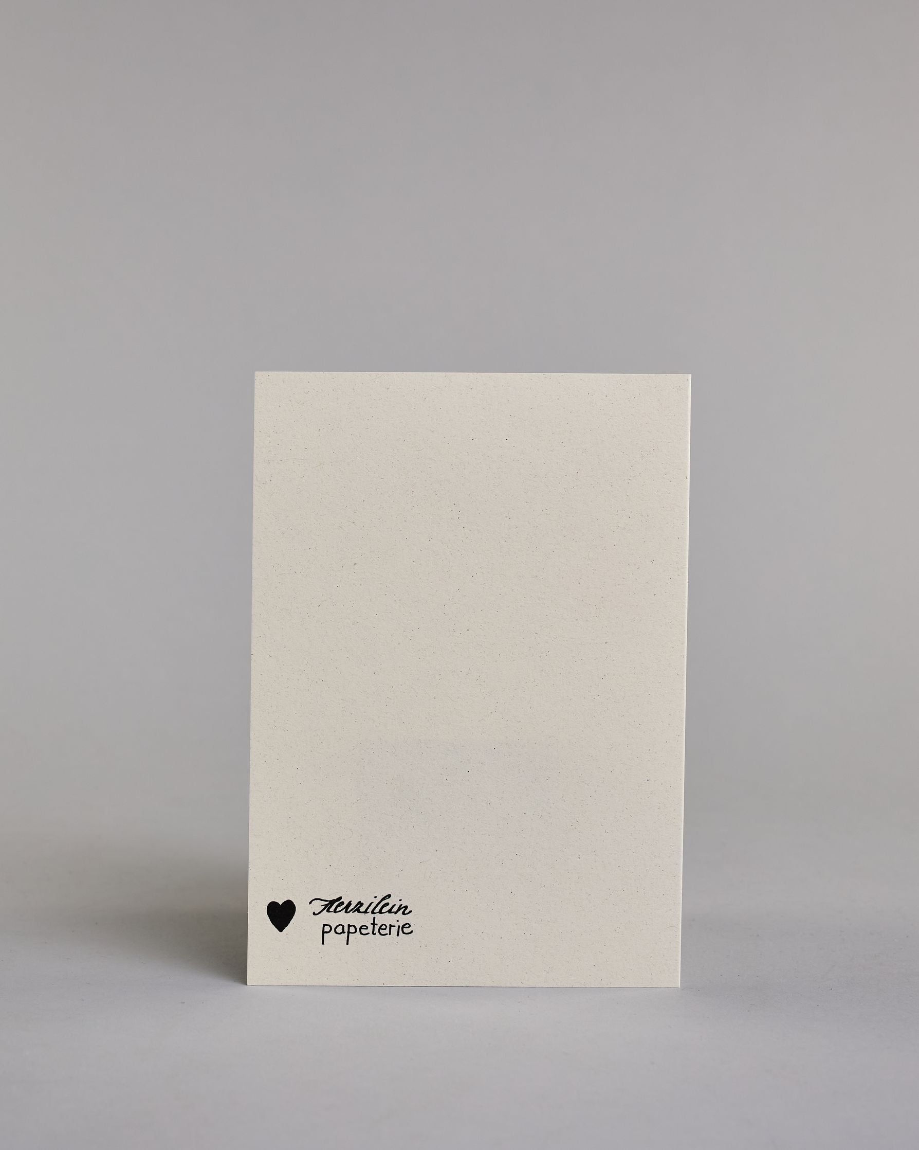 Glückwunschkarte zur Hochzeit mit der Kalligrafieaufschrift "Traumpaar Gratulation" auf hellem Hintergrund. In der Mitte eines runden, handgezeichneten Blätterkranzes, der mit goldfarbenen Akzenten versehen ist, steht in schwarzer Schrift das Wort „TRAUM PAAR“ auf zwei Zeilen. Darunter steht in größerer, geschwungener schwarzer Schrift das Wort „Gratulation“. Dazu ein gold-weißes handgeschöpftes Kuvert. #4