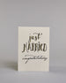 Glückwunschkarte zur Hochzeit in Englisch mit der Kalligrafieaufschrift "just MARRIED congratulations" auf hellem Hintergrund. Oben in schwungvoller schwarzer Schrift steht das Wort „just“. Darunter in größerer, dekorativer Schrift mit goldfarbenen Akzenten das Wort „MARRIED“. Der Punkt vom „I“ ist ein kleines Herz. Am unteren Rand der Karte steht in eleganter, geschwungener schwarzer Schrift „congratulations“. Dazu ein gold-weißes handgeschöpftes Kuvert. #1