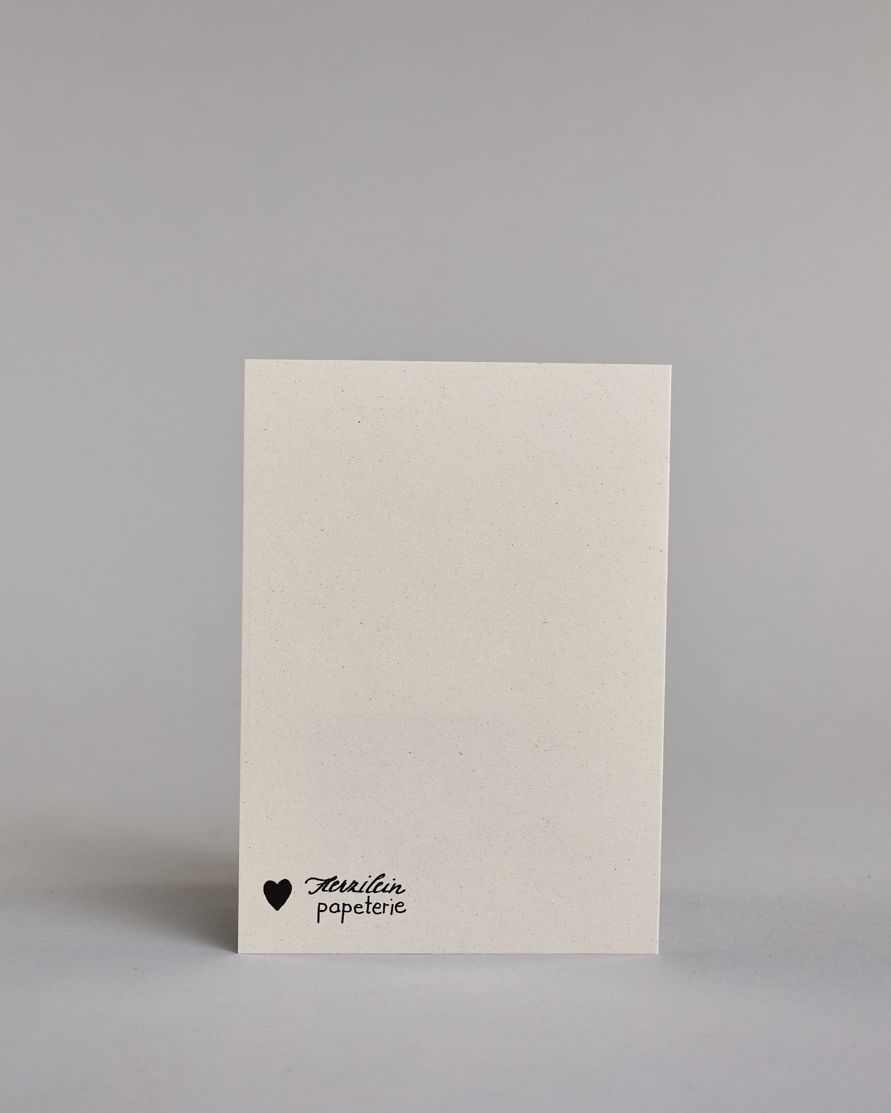 Glückwunschkarte zur Hochzeit mit der Kalligrafieaufschrift "Manchses gehört einfach zusammen so wie ihr beide" auf einem hellen Hintergrund. Sie zeigt den Text in verschiedenen Schriften und Größen: Oben steht in schmaler, schwarzer Druckschrift „MANCHES GEHÖRT EINFACH“, darunter in schwungvoller, kleinerer Schreibschrift „zusammen“, darunter wieder in schmaler Druckschrift „SO WIE“ und am unteren Rand in großer, geschwungener Schrift mit goldfarbenen Akzenten „ihr beide“, unterstrichen von einem dekorati…