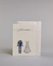 Glückwunschkarte auf Englisch zur Hochzeit mit schwarzer Kalligrafieaufschrift "just married", darunter ein schwarzer Anzug und rechts daneben ein weißes Hochzeitskleid. Der Text "just married" ist in geschwungener schwarzer Kalligraphieschrift und zieht sich von ganz links nach ganz rechts über die Karte, außerdem befindet sich im Schwung der Schrift in der Mitte der beiden Worte ein Herz und alles ist auf hellem Hintergrund. Dazu ein weißes handgeschöpftes Kuvert. #2