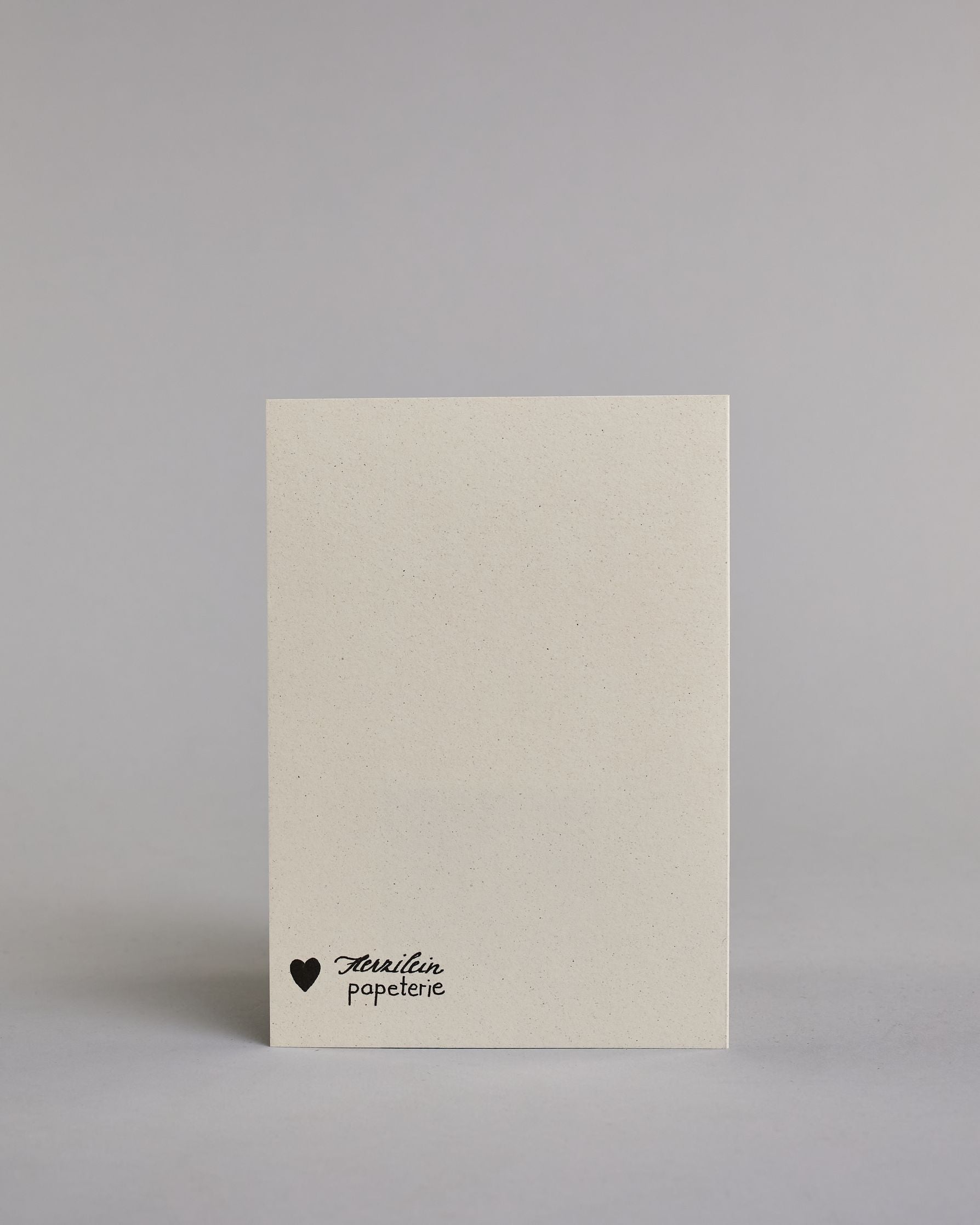 Klappkarte für Liebende mit schwarzer Kalligrafieaufschrift "Du machst mich glücklich" auf hellem Hintergrund. Der Text ist in vier Zeilen mit jeweils einem Wort aufgeteilt und in einer sehr schwungvollen dünnen Kalligrafieschrift gestaltet. Dazu ein gold-weißes handgeschöpftes Kuvert. #4