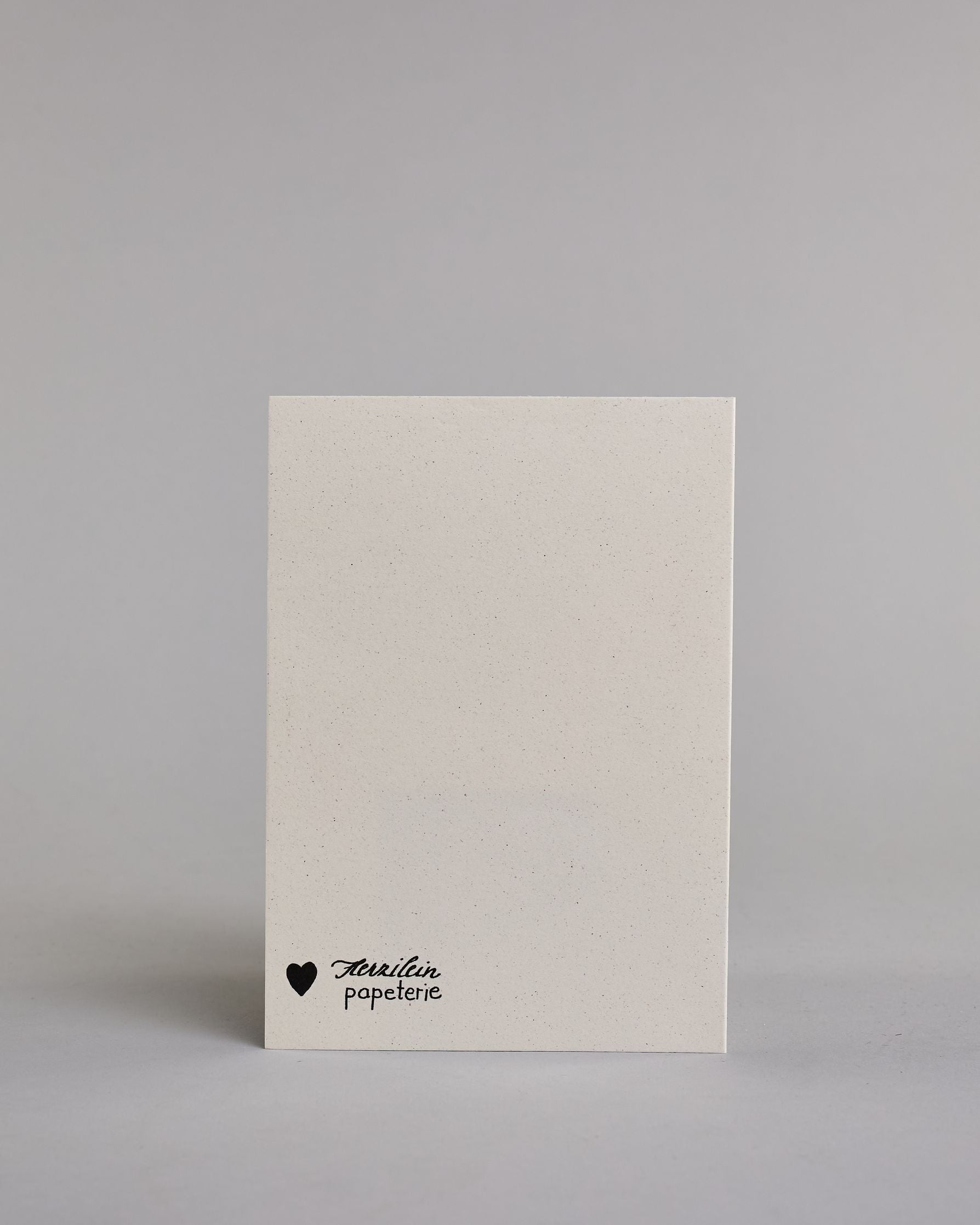 Klappkarte für Liebende in Englisch mit schwarzer Kalligrafieaufschrift "we belong together" mit zwei gezeichneten Bienen und einem Herz über dem Text auf hellem Hintergrund. Der Text ist in folgende zwei Zeilen aufgeteilt: "we BEE long" - das "BEE" ist als einziges Wort in Großbuchstaben gestaltet und wie als das Wort "Biene" und nicht "sein" geschrieben, darunter "together". Der Text ist in verspielter Schreibschrift gestaltet. Dazu ein handgeschöpftes Kuvert. #4