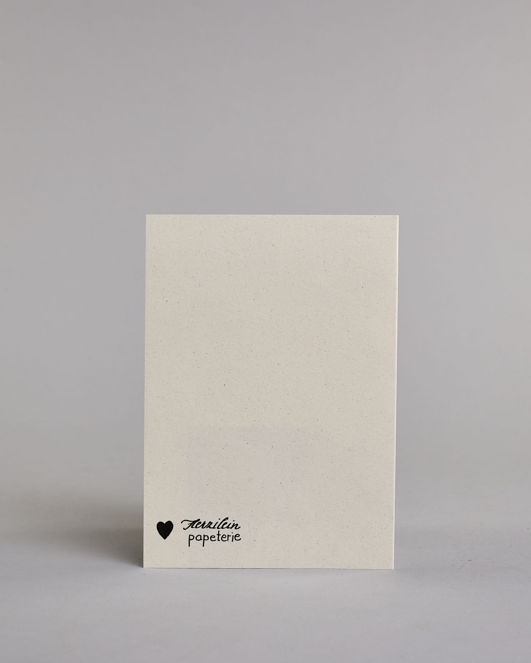 Klappkarte für Liebende auf Französisch mit schwarzer Kalligrafieaufschrift "je t'aime" auf hellem Hintergrund. Der Text ist in einer Zeile und in einer Schreibschrift gestaltet. Dazu ein rot-weißes handgeschöpftes Kuvert. #4