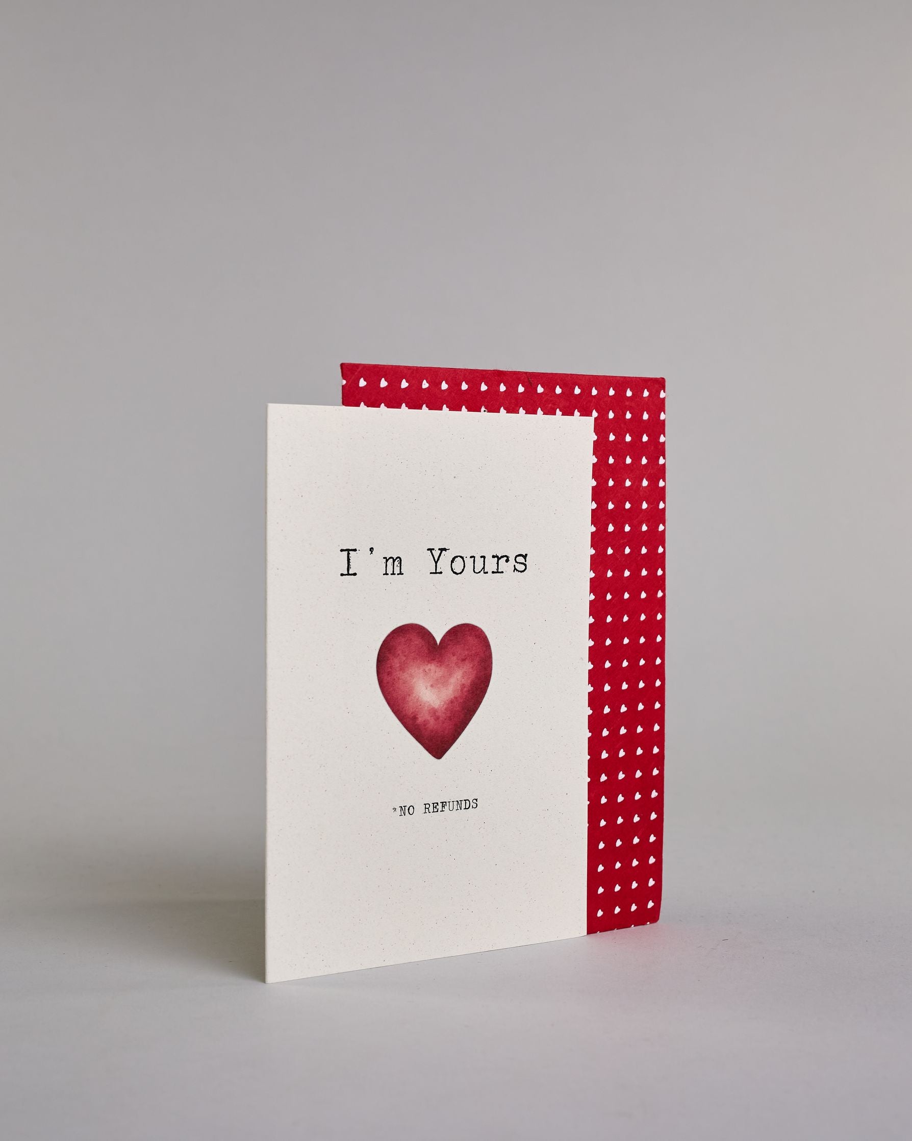 Klappkarte für Liebende auf Englisch mit schwarzer und Kalligrafieaufschrift "I'm yours *no refunds" mit einem Herz im Wasserfarbenstil auf hellem Hintergrund. Der Text ist in folgende zwei Zeilen aufgeteilt: "I'm Yours", darunter das rote Herz, darunter "*NO REFUNDS" beide Textzeilen in tyischer Schreibmaschinenschrift, das "*NO REFUNDS" ist allerdings viel kleiner, wie das Kleingedrukte in einem Vertrag. Dazu ein rot-weißes handgeschöpftes Kuvert. #3