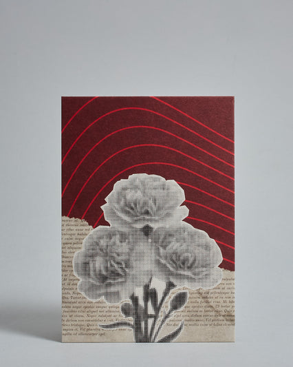 Die Vorderseite der Postkarte im Hochformat vor hellgrauem Hintergrund. Die Postkarte ist im Retro-Stil, gedruckt auf Holzschiffpappe und zeigt eine Blume im Halbtonraster (schwarz auf weiß) auf einem schräg horizontal geteilten Hinergrund. Die ober Häfte des Hintergrundes ist in dunkelrot mit hellroten geschwungenen Linien. Die untere Hälfte sieht aus wie gerissene Seite aus einem alten Buch.