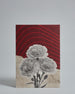 Die Vorderseite der Postkarte im Hochformat vor hellgrauem Hintergrund. Die Postkarte ist im Retro-Stil, gedruckt auf Holzschiffpappe und zeigt eine Blume im Halbtonraster (schwarz auf weiß) auf einem schräg horizontal geteilten Hinergrund. Die ober Häfte des Hintergrundes ist in dunkelrot mit hellroten geschwungenen Linien. Die untere Hälfte sieht aus wie gerissene Seite aus einem alten Buch.