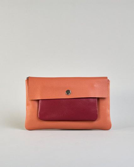 Kosmetiktasche aus Leder mit einem großen orangenen Zippfach und einem kleinen roten Zippfach vorne, darüber eine orangene Lasche mit Druckknopf. #1