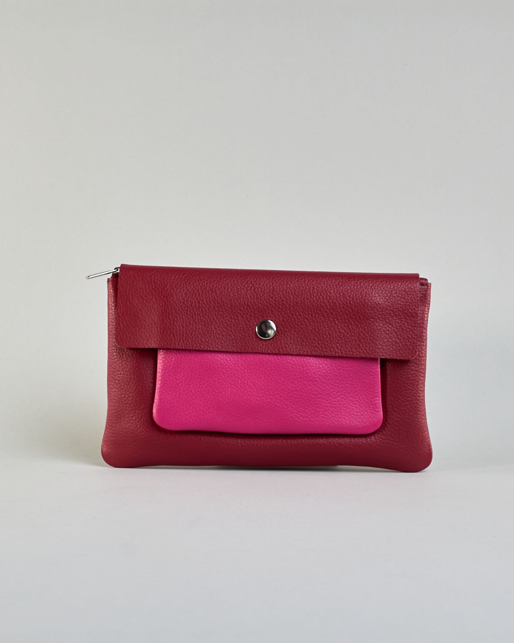 Kosmetiktasche aus Leder mit einem großen bordeauxroten Zippfach und einem kleinen pinken Zippfach vorne, darüber eine  bordauxrote Lasche mit Druckknopf. #1