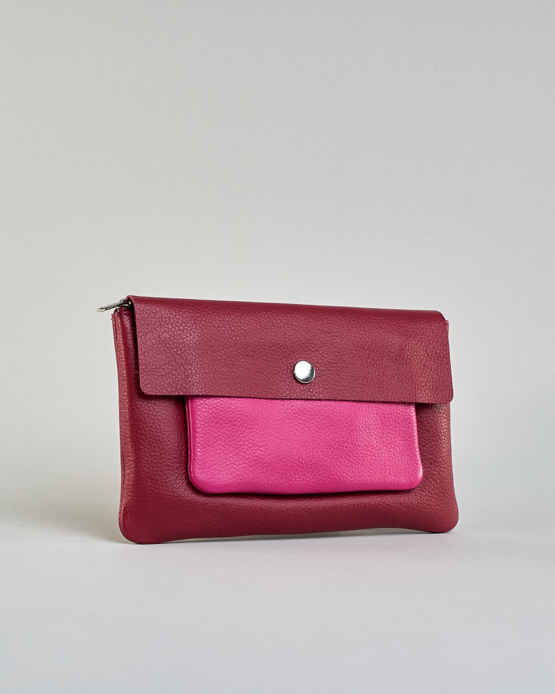 Kosmetiktasche aus Leder mit einem großen bordeauxroten Zippfach und einem kleinen pinken Zippfach vorne, darüber eine  bordauxrote Lasche mit Druckknopf. #2