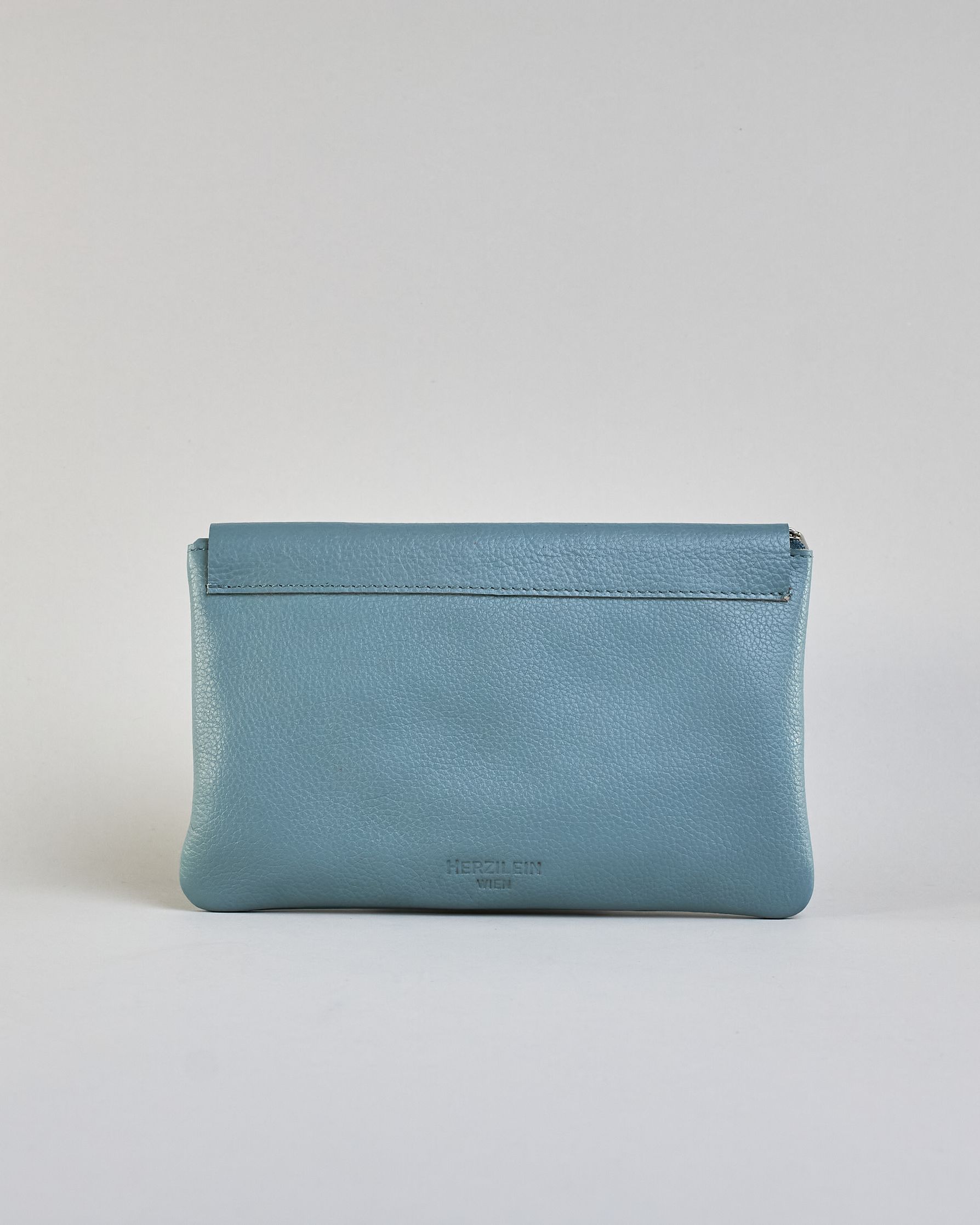 Kosmetiktasche aus Leder mit einem großen jeansblauen  Zippfach und einem kleinen dunkelblauen Zippfach vorne, darüber eine jeansblauen Lasche mit Druckknopf. #3