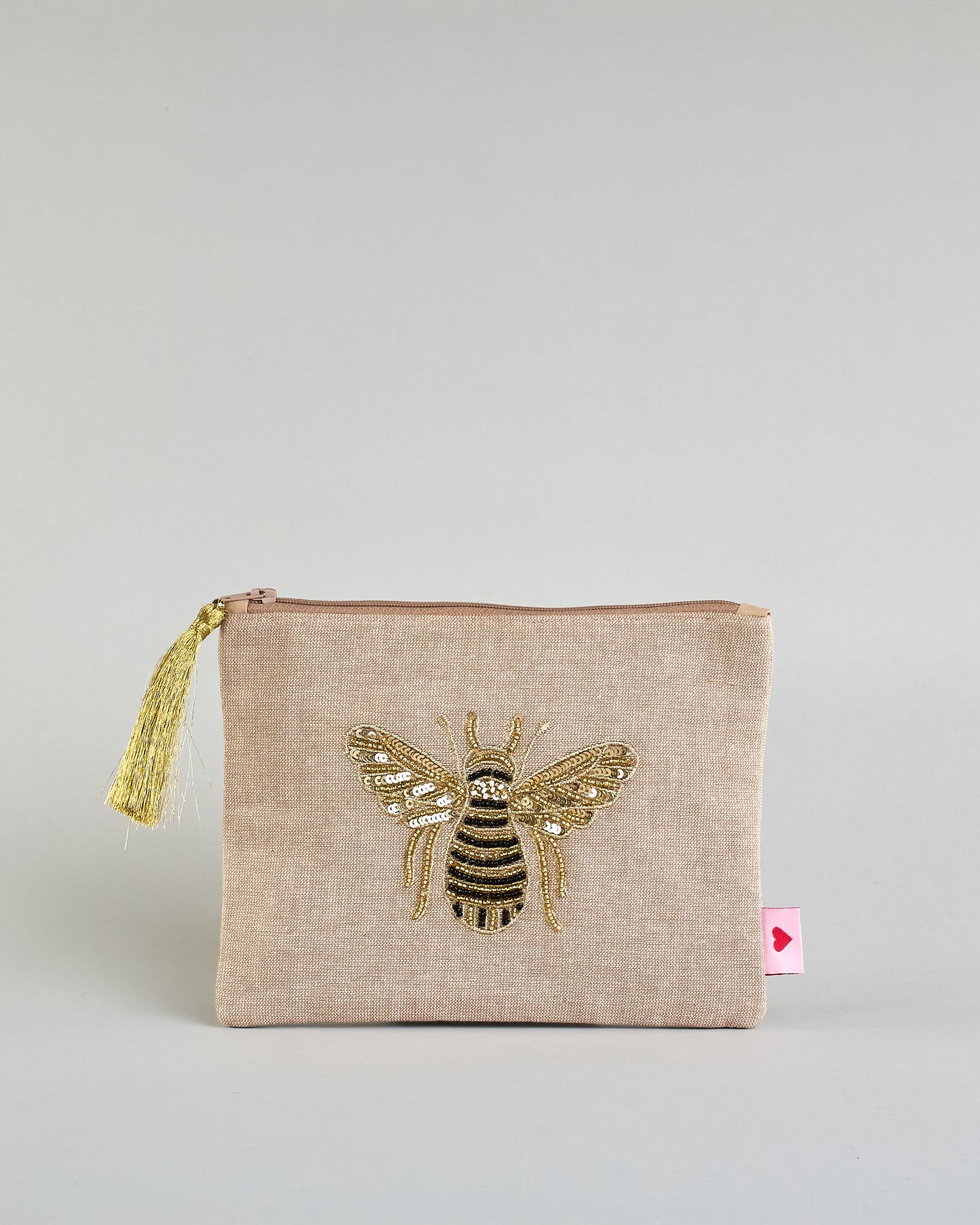 Beige Kosmetiktasche aus Baumwolle mit großer Biene aus Perlenstickerei mittig auf der Tasche. Goldene Quaste am Zippverschluss #1