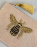 Beige Kosmetiktasche aus Baumwolle mit großer Biene aus Perlenstickerei mittig auf der Tasche. Goldene Quaste am Zippverschluss #3