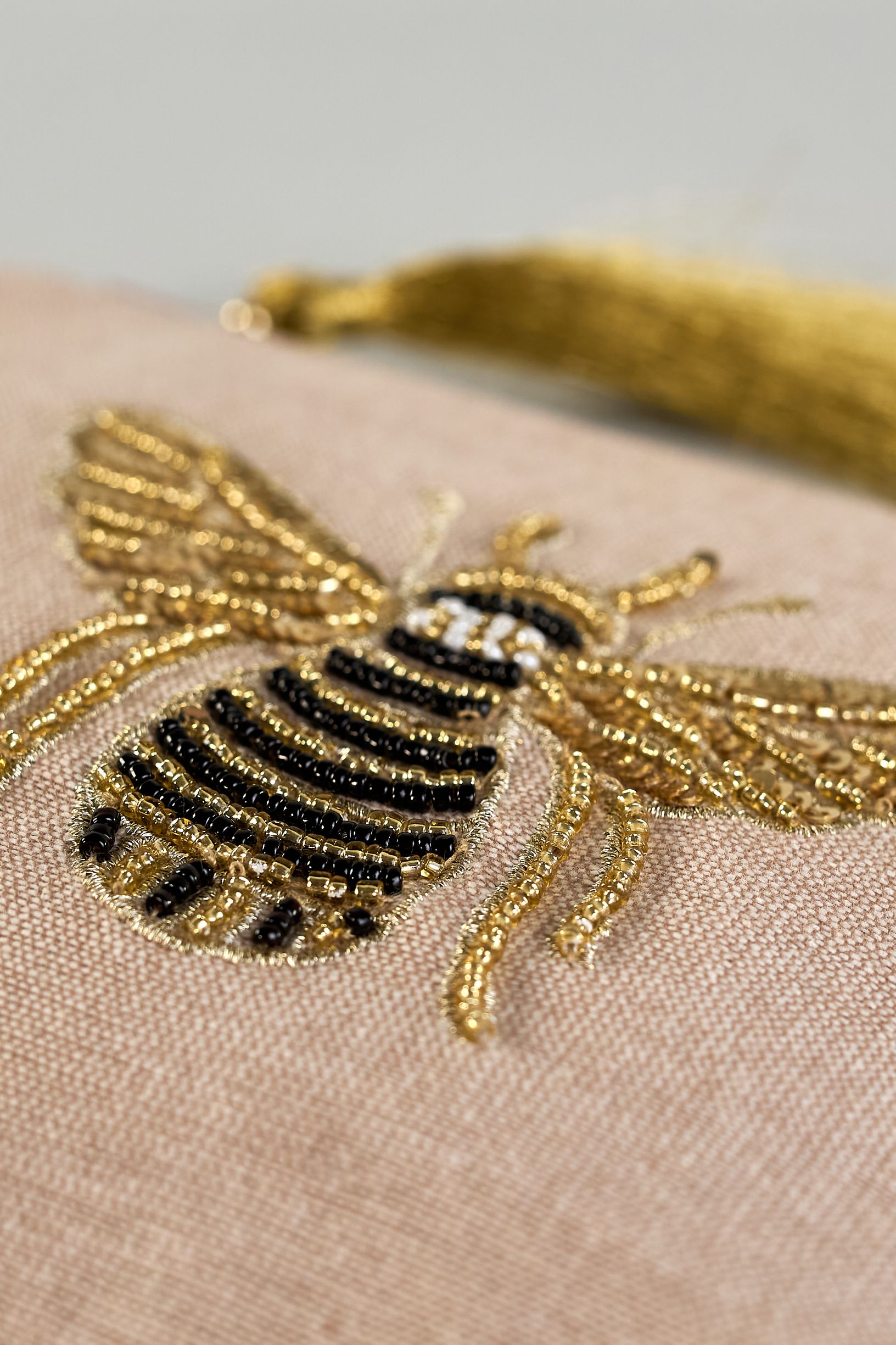 Beige Kosmetiktasche aus Baumwolle mit großer Biene aus Perlenstickerei mittig auf der Tasche. Goldene Quaste am Zippverschluss #4