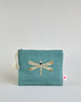 Mintfarbene Kosmetiktasche aus Baumwolle mit großer Libelle aus Perlenstickerei mittig auf der Tasche. Goldene Quaste am Zippverschluss #1