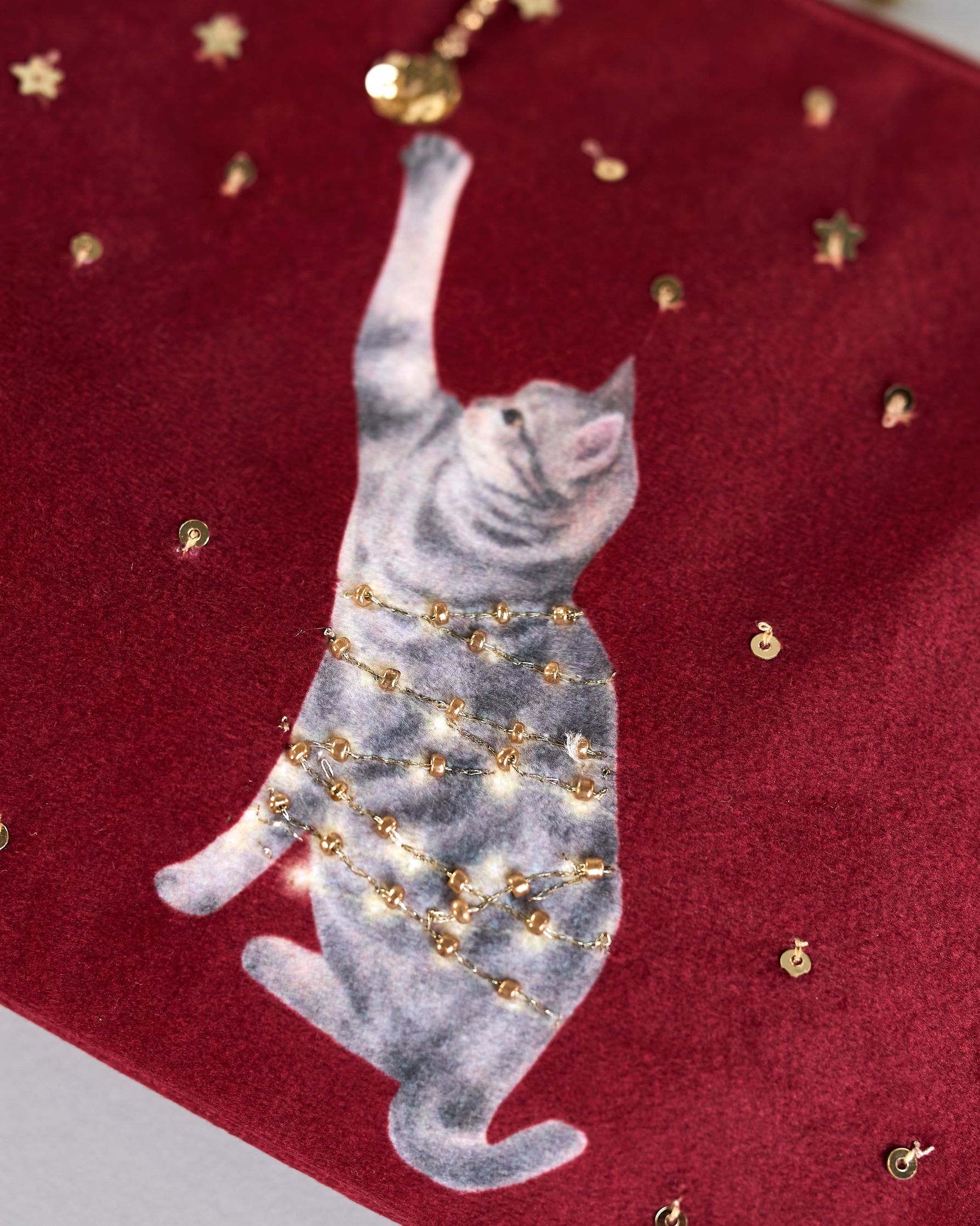 Bordeauxrote Kosmetiktasche aus Samt mit einer Katze die in eine Lichterkette gewickelt ist und mit einer Weihnachtskugel spielt. Mit schönen Details aus Perlen und Pailetten und einer goldenen Quaste am Zippverschluss #3
