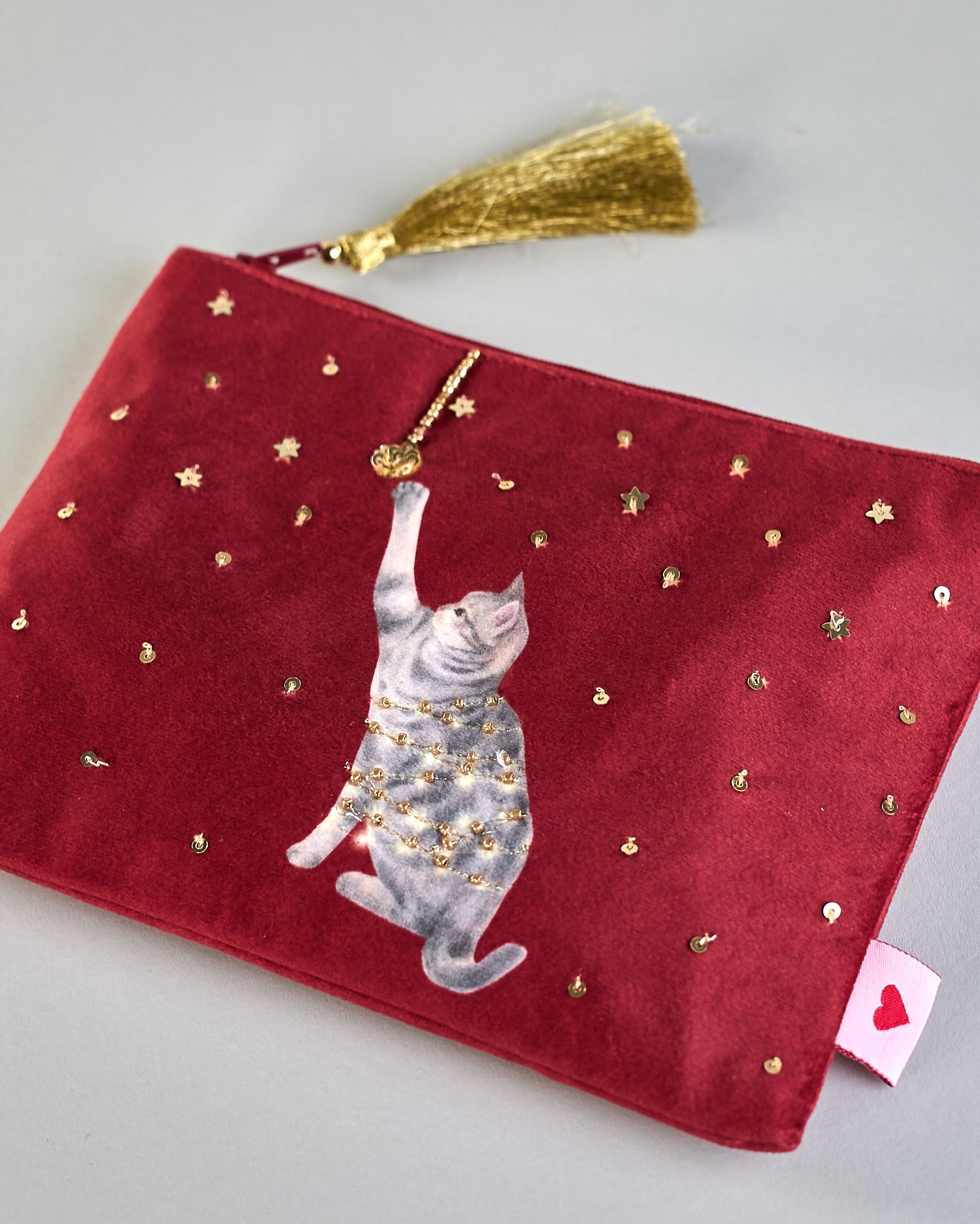 Bordeauxrote Kosmetiktasche aus Samt mit einer Katze die in eine Lichterkette gewickelt ist und mit einer Weihnachtskugel spielt. Mit schönen Details aus Perlen und Pailetten und einer goldenen Quaste am Zippverschluss #4