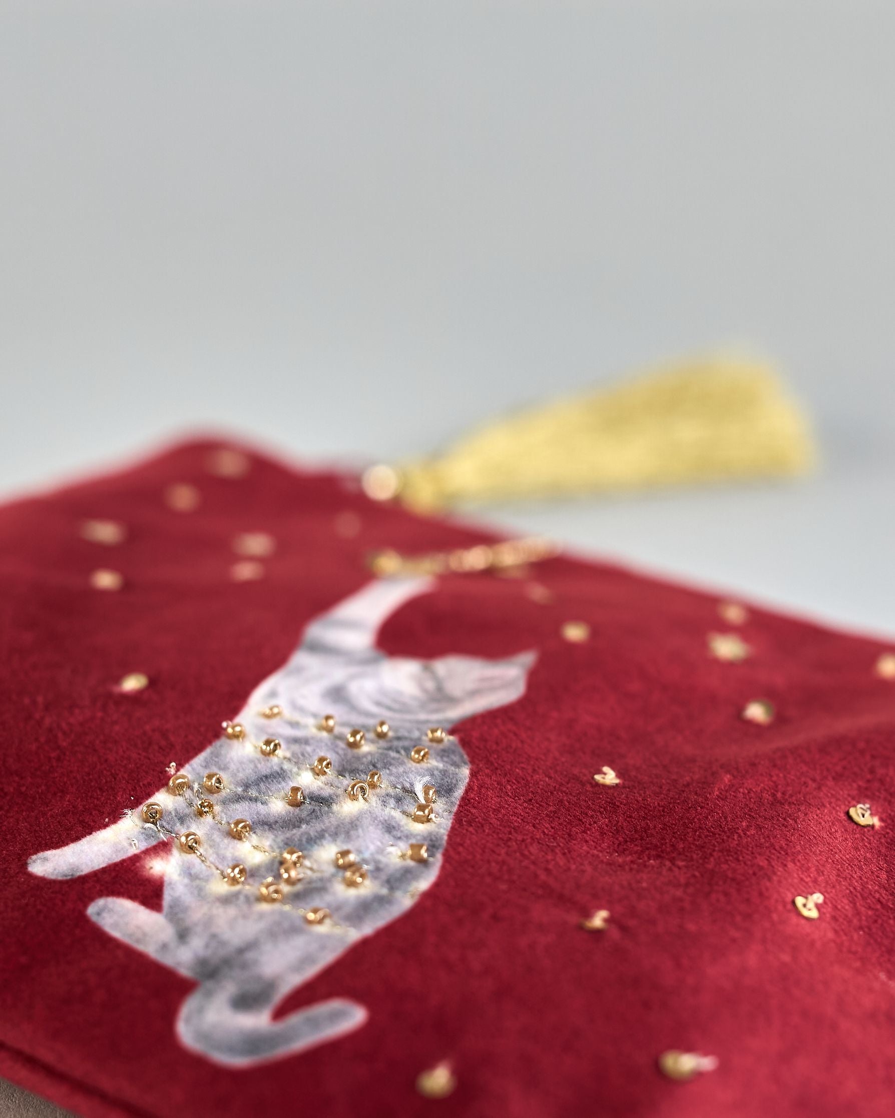 Bordeauxrote Kosmetiktasche aus Samt mit einer Katze die in eine Lichterkette gewickelt ist und mit einer Weihnachtskugel spielt. Mit schönen Details aus Perlen und Pailetten und einer goldenen Quaste am Zippverschluss #6