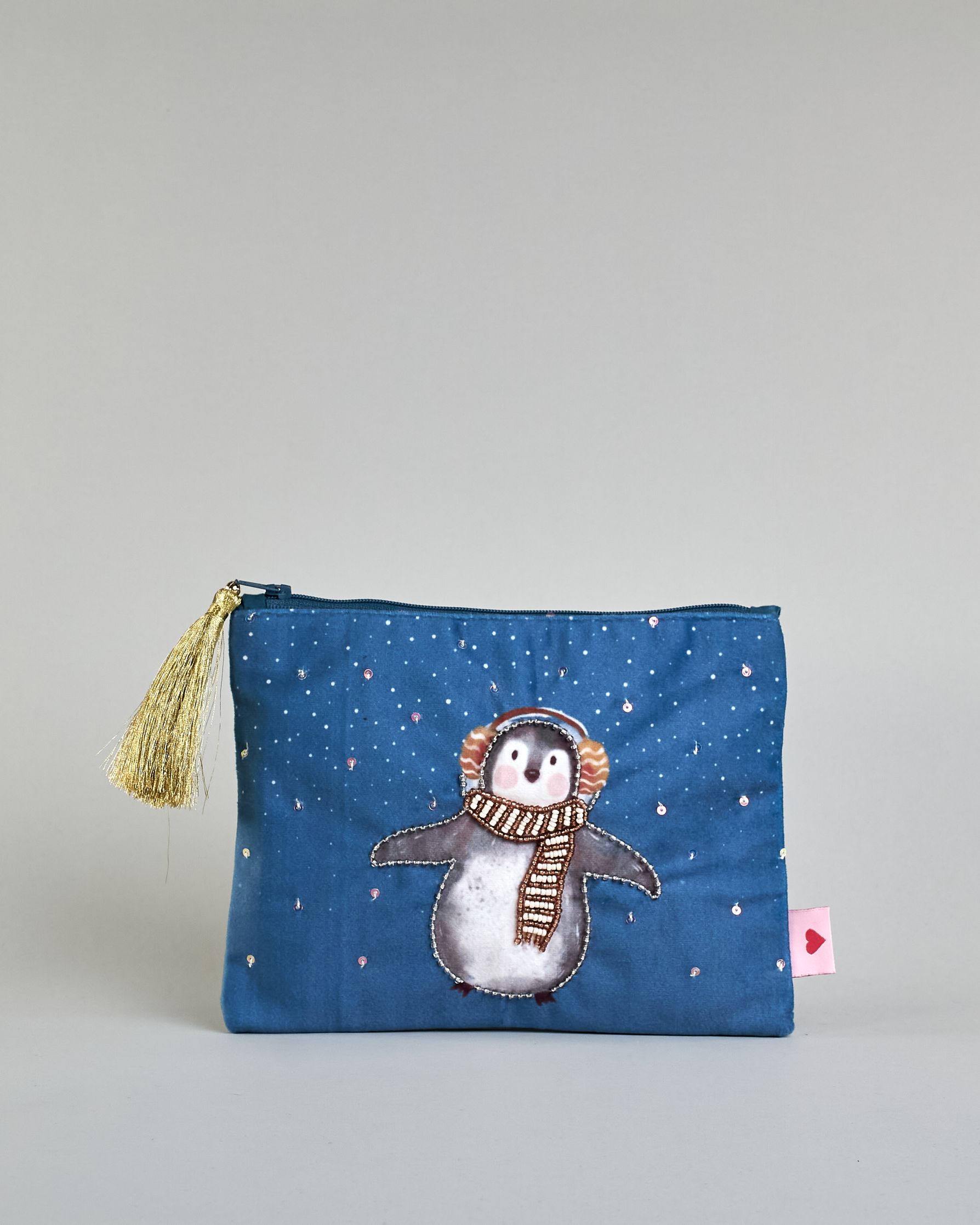 Blaue Kosmetiktasche aus Samt mit einem Pinguin mit Schal und Ohrenschützern der im Schnee tanzt. Mit schönen Details aus Perlen und Pailetten und einer goldenen Quaste am Zippverschluss #1