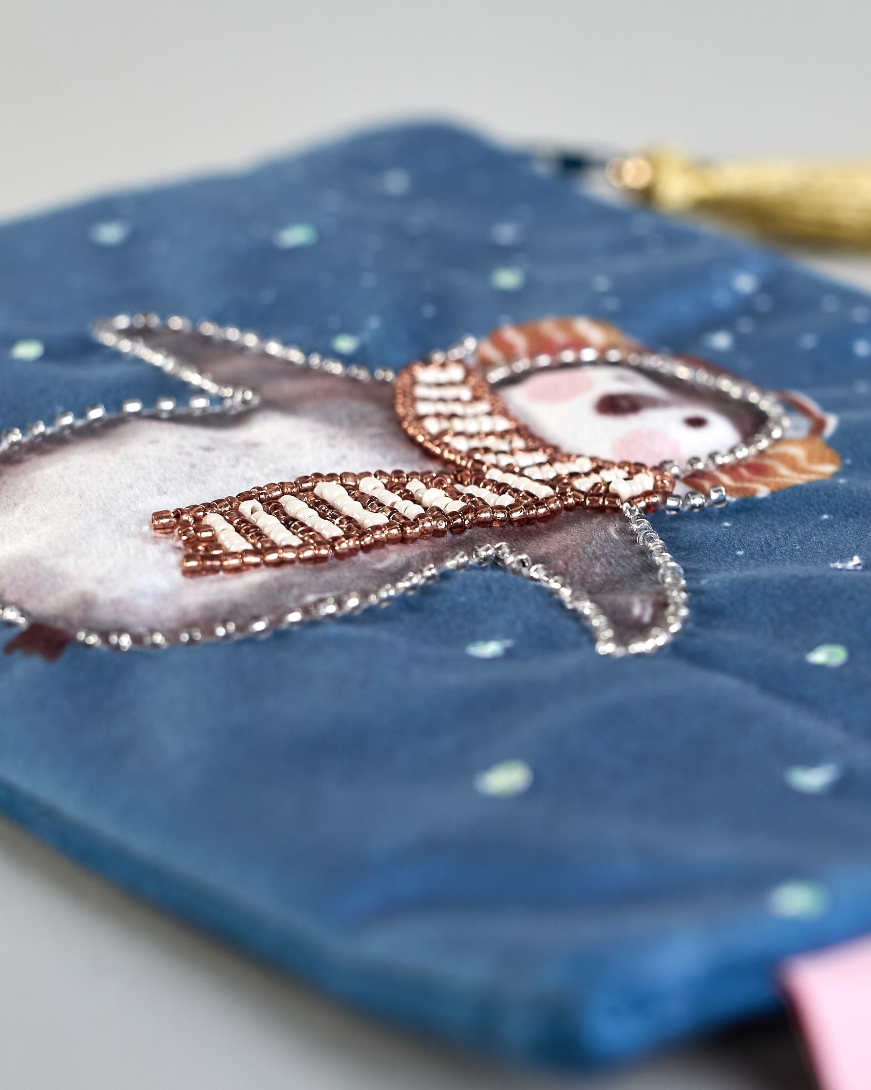 Blaue Kosmetiktasche aus Samt mit einem Pinguin mit Schal und Ohrenschützern der im Schnee tanzt. Mit schönen Details aus Perlen und Pailetten und einer goldenen Quaste am Zippverschluss #3