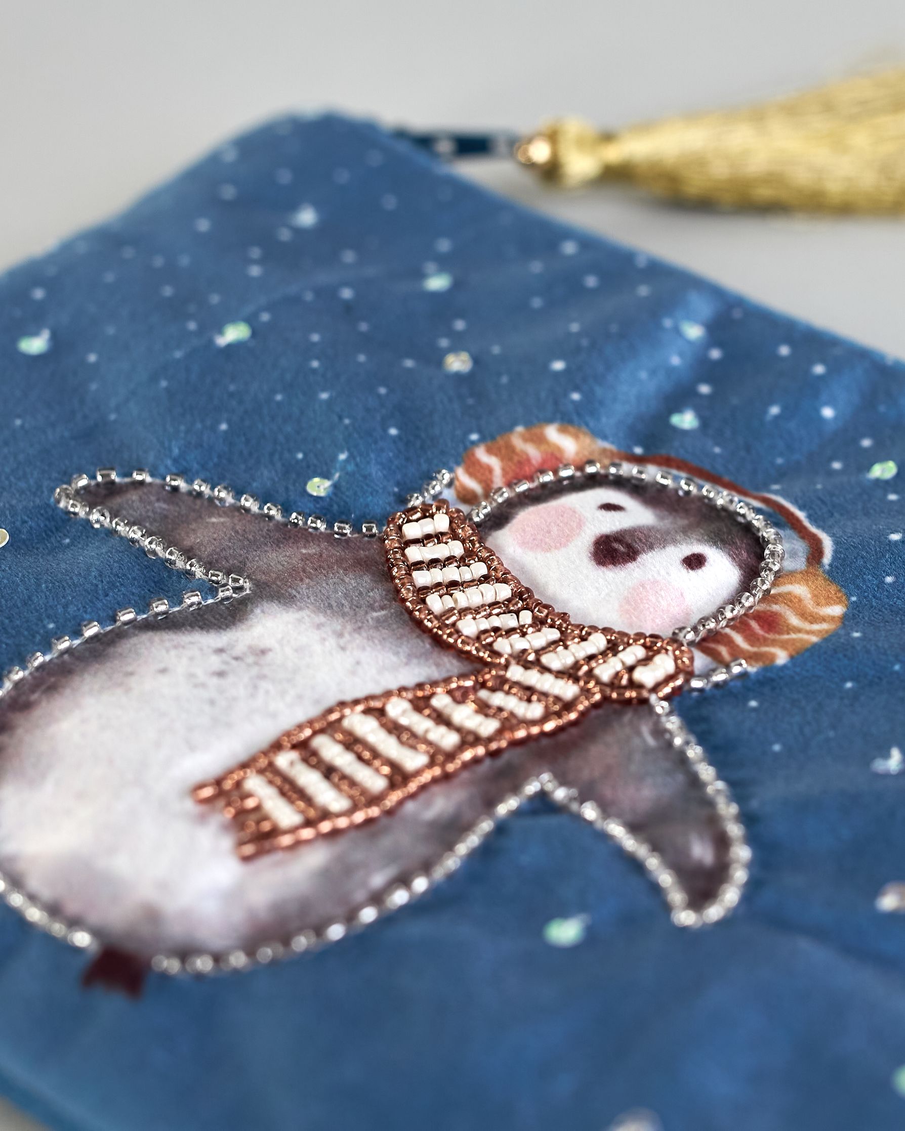 Blaue Kosmetiktasche aus Samt mit einem Pinguin mit Schal und Ohrenschützern der im Schnee tanzt. Mit schönen Details aus Perlen und Pailetten und einer goldenen Quaste am Zippverschluss #5