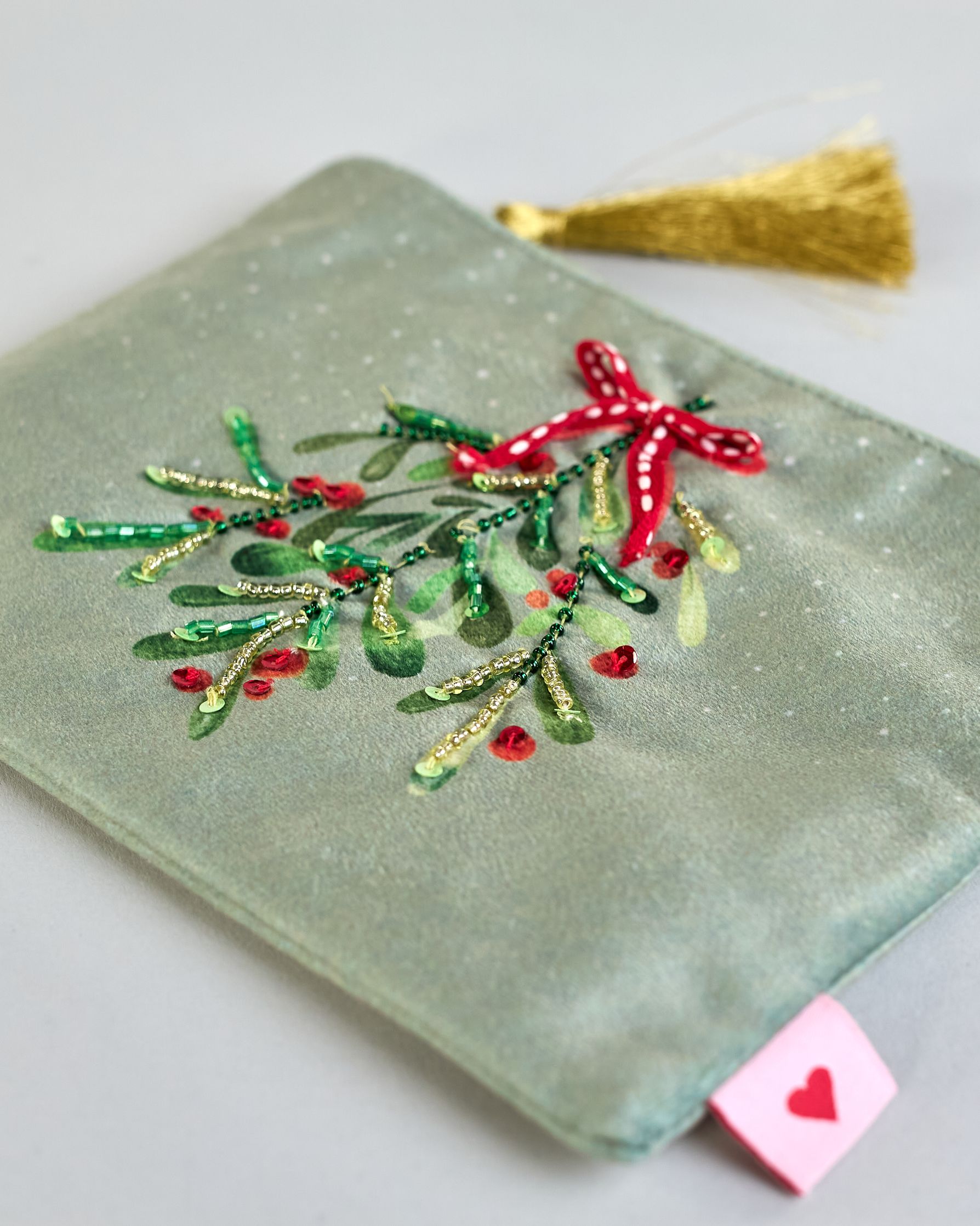 Mintfarbene Kosmetiktasche aus Samt mit einem Mistelzweig und einer roten Tasche. Mit schönen Details aus Perlen und Pailetten und einer goldenen Quaste am Zippverschluss. #4