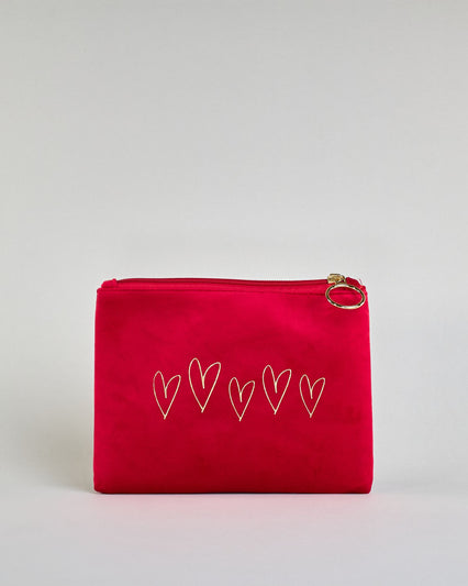 Rote Kosmetiktasche aus Samtstoff mit großem goldenem Aufdruck von fünf Herzensymbolen in der Mitte. Zipp mit goldenem Metallring zum Verschließen. Futter aus Satinstoff in Kontrastfarbe. #1
