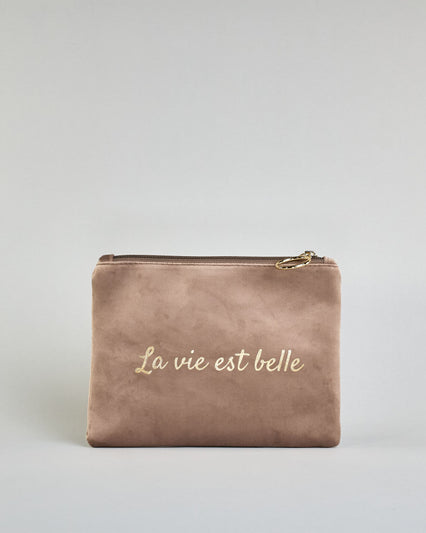Beige Kosmetiktasche aus Samtstoff mit großem goldenem Aufdruck "La vie est belle" in der Mitte. Zipp mit goldenem Metallring zum Verschließen. Futter aus Satinstoff in Kontrastfarbe. #1