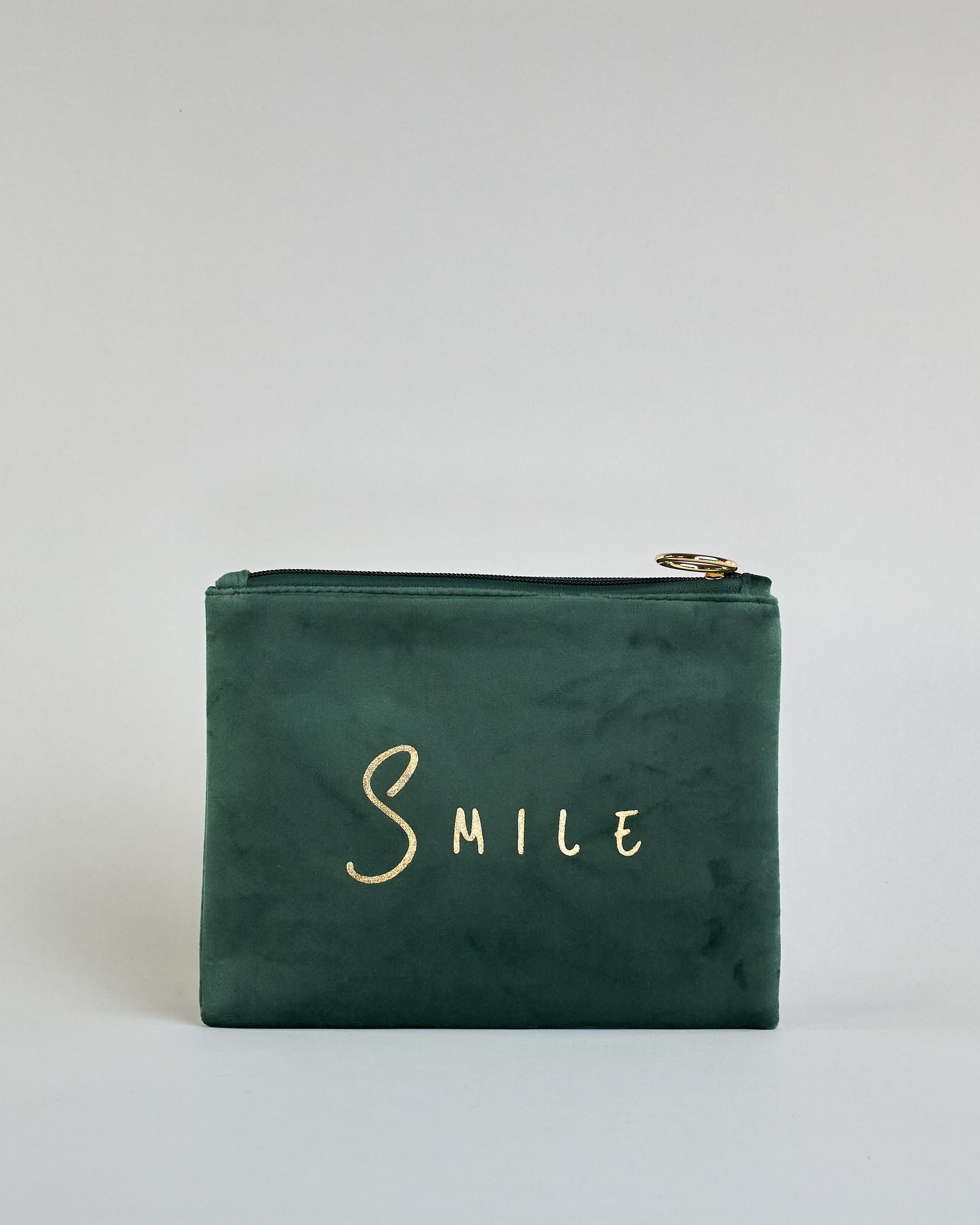 Dunkelgrüne  Kosmetiktasche aus Samtstoff mit großem goldenem Aufdruck "Smile" in der Mitte. Zipp mit goldenem Metallring zum Verschließen. Futter aus Satinstoff in Kontrastfarbe. #1