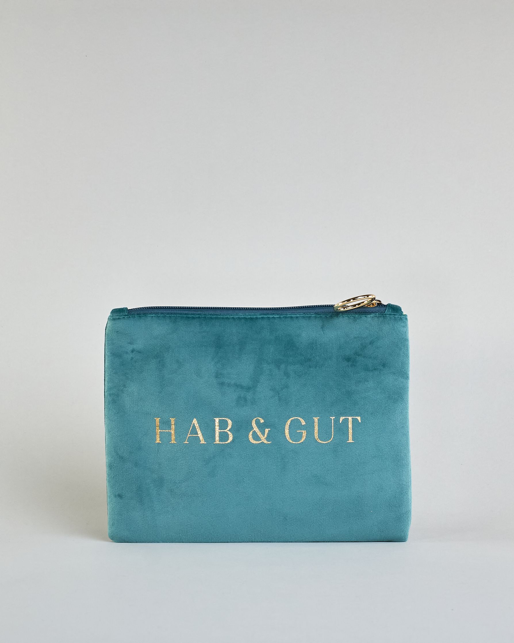 Petrolfarbene Kosmetiktasche aus Samtstoff mit großem goldenem Aufdruck "Hab & Gut" in der Mitte. Zipp mit goldenem Metallring zum Verschließen. Futter aus Satinstoff in Kontrastfarbe. #1