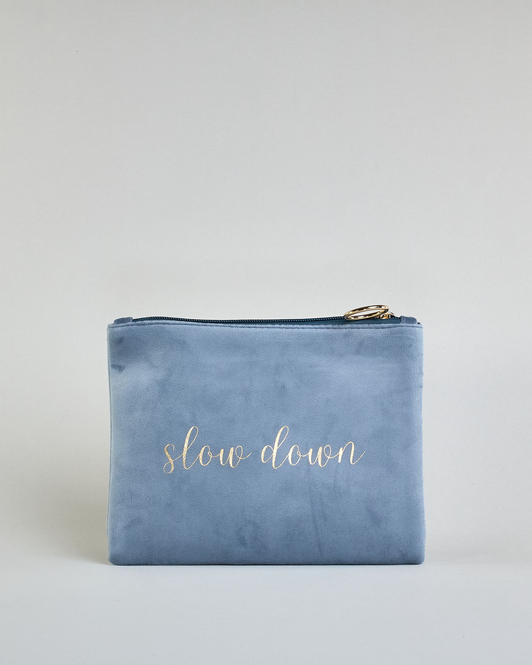 Hellblaue Kosmetiktasche aus Samtstoff mit großem goldenem Aufdruck "Slow down" in der Mitte. Zipp mit goldenem Metallring zum Verschließen. Futter aus Satinstoff in Kontrastfarbe. #1