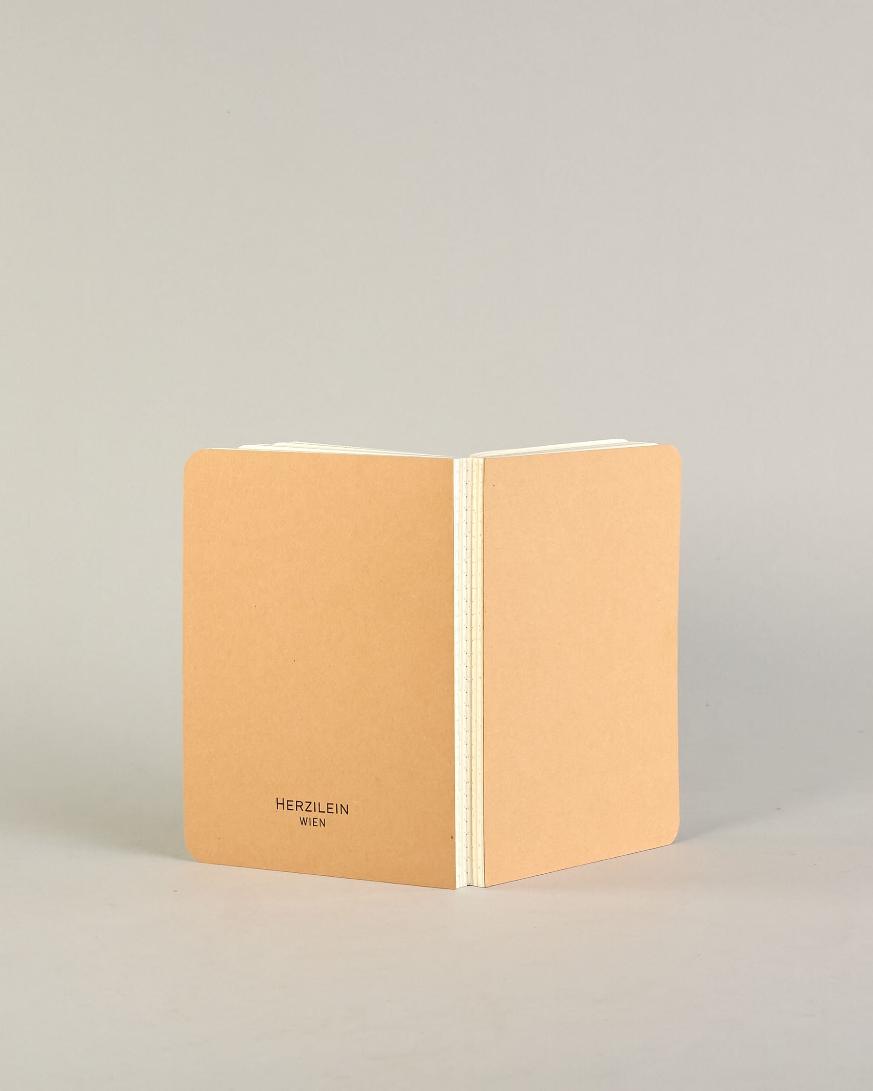 Simples Notizbuch mit Kraft Karton Einband, offener Buchbindung und Logo Print "Herzilein-Wien" in schwarz, klein auf der Rückseite. #13