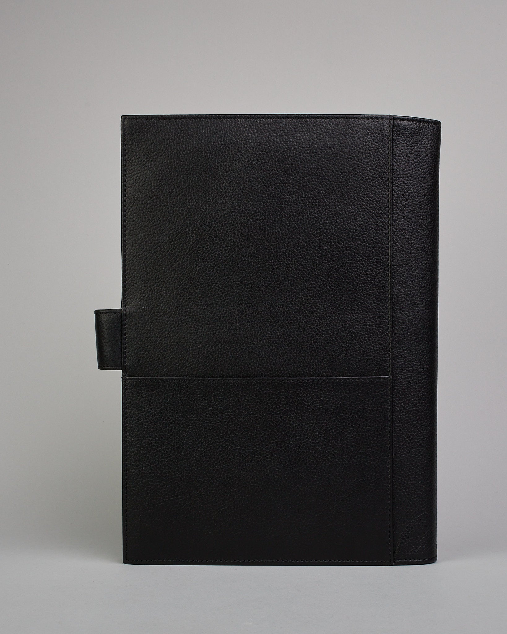 Schwarzer Leder Notizbucheinband mit leichter Narbund. Der Einband hat außen ein flaches Fach in das ein Stift und das Handy gesteckt werden können. Das Notizbuch lässt sich seitlich mit einer Lasche und einem darunterliegenden Druckknopf verschließen. Innen bietet das Notizbuch rechts Platz um ein Buch einzustecken und links gibt es viele Fächer für weitere Notizzettel, Visitkarten und mehr. #3