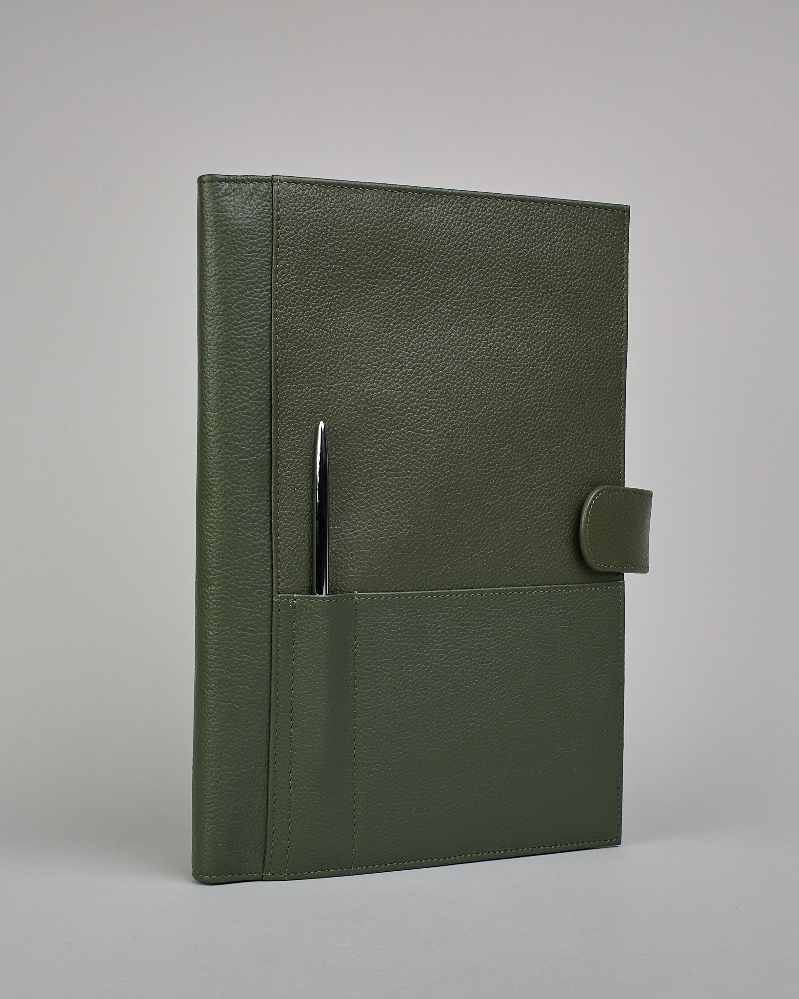 Dunkelgrüner Leder Notizbucheinband mit leichter Narbund. Der Einband hat außen ein flaches Fach in das ein Stift und das Handy gesteckt werden können. Das Notizbuch lässt sich seitlich mit einer Lasche und einem darunterliegenden Druckknopf verschließen. Innen bietet das Notizbuch rechts Platz um ein Buch einzustecken und links gibt es viele Fächer für weitere Notizzettel, Visitkarten und mehr. #1