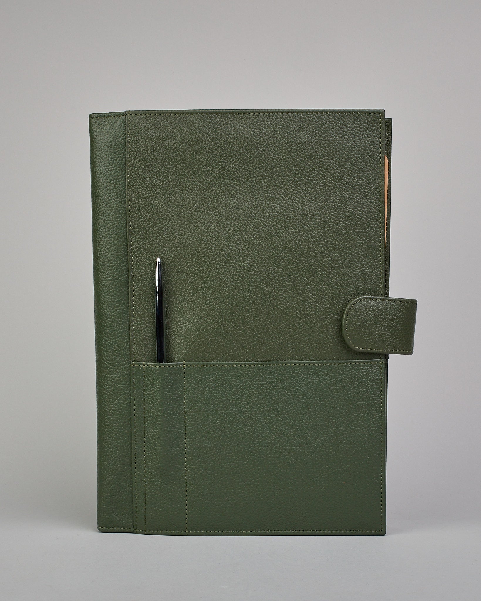 Dunkelgrüner Leder Notizbucheinband mit leichter Narbund. Der Einband hat außen ein flaches Fach in das ein Stift und das Handy gesteckt werden können. Das Notizbuch lässt sich seitlich mit einer Lasche und einem darunterliegenden Druckknopf verschließen. Innen bietet das Notizbuch rechts Platz um ein Buch einzustecken und links gibt es viele Fächer für weitere Notizzettel, Visitkarten und mehr. #2