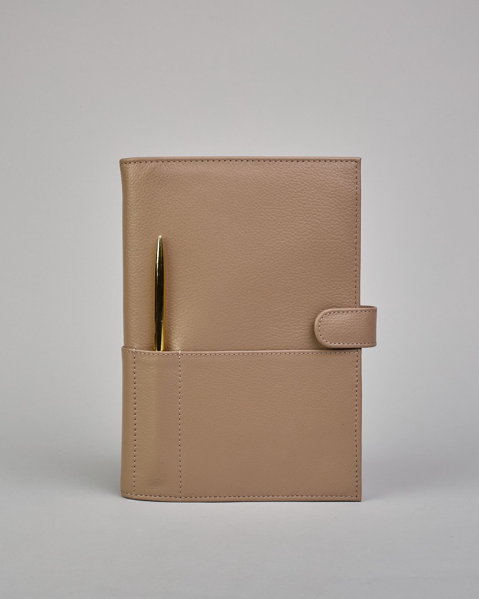 Beiger Leder Notizbucheinband mit leichter Narbund. Der Einband hat außen ein flaches Fach in das ein Stift und das Handy gesteckt werden können. Das Notizbuch lässt sich seitlich mit einer Lasche und einem darunterliegenden Druckknopf verschließen. Innen bietet das Notizbuch rechts Platz um ein Buch einzustecken und links gibt es viele Fächer für weitere Notizzettel, Visitkarten und mehr. #2