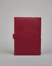 Bordeauxroter Leder Notizbucheinband mit leichter Narbund. Der Einband hat außen ein flaches Fach in das ein Stift und das Handy gesteckt werden können. Das Notizbuch lässt sich seitlich mit einer Lasche und einem darunterliegenden Druckknopf verschließen. Innen bietet das Notizbuch rechts Platz um ein Buch einzustecken und links gibt es viele Fächer für weitere Notizzettel, Visitkarten und mehr. #3