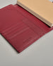 Bordeauxroter Leder Notizbucheinband mit leichter Narbund. Der Einband hat außen ein flaches Fach in das ein Stift und das Handy gesteckt werden können. Das Notizbuch lässt sich seitlich mit einer Lasche und einem darunterliegenden Druckknopf verschließen. Innen bietet das Notizbuch rechts Platz um ein Buch einzustecken und links gibt es viele Fächer für weitere Notizzettel, Visitkarten und mehr. #6