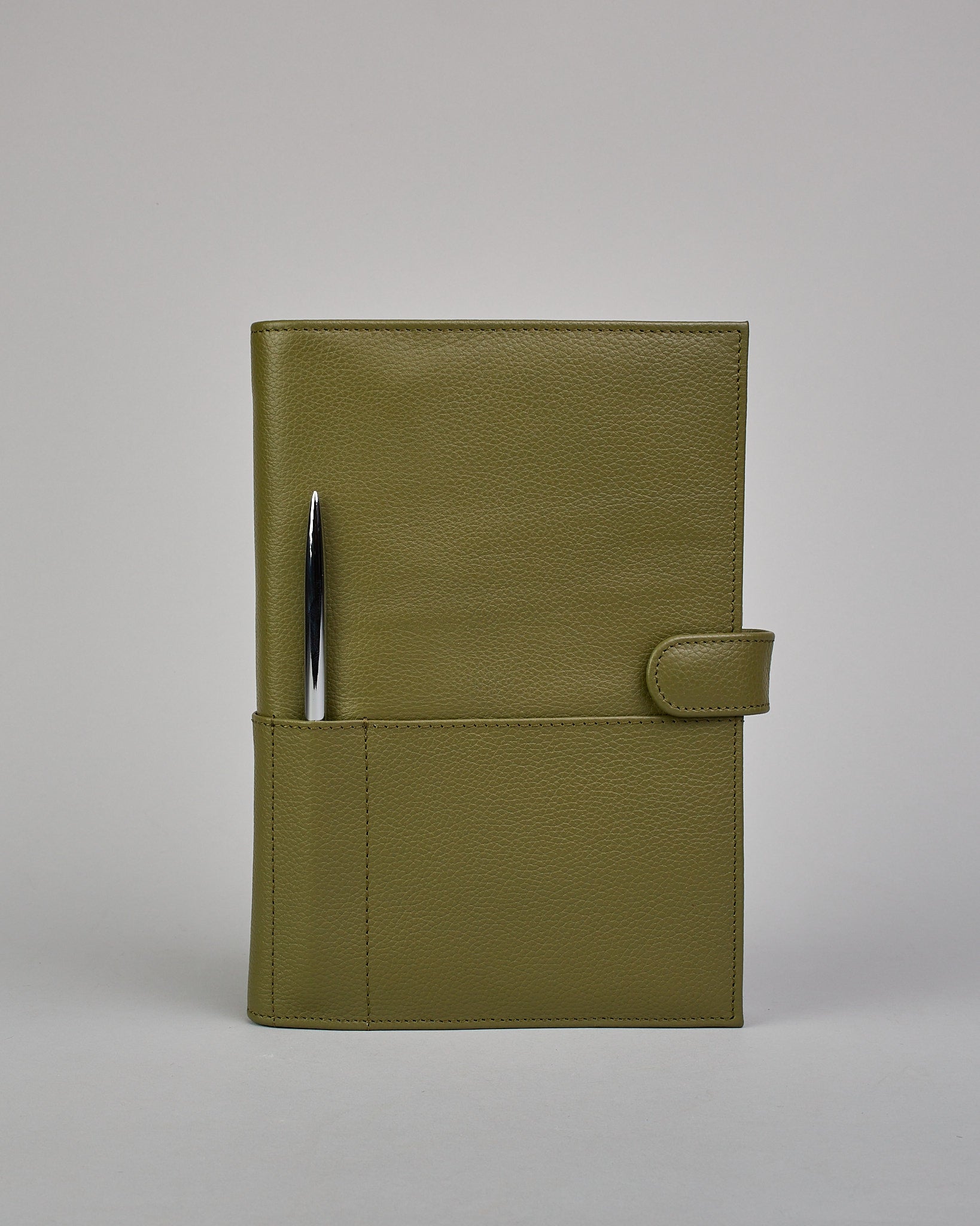 Grüner Leder Notizbucheinband mit leichter Narbund. Der Einband hat außen ein flaches Fach in das ein Stift und das Handy gesteckt werden können. Das Notizbuch lässt sich seitlich mit einer Lasche und einem darunterliegenden Druckknopf verschließen. Innen bietet das Notizbuch rechts Platz um ein Buch einzustecken und links gibt es viele Fächer für weitere Notizzettel, Visitkarten und mehr. #2
