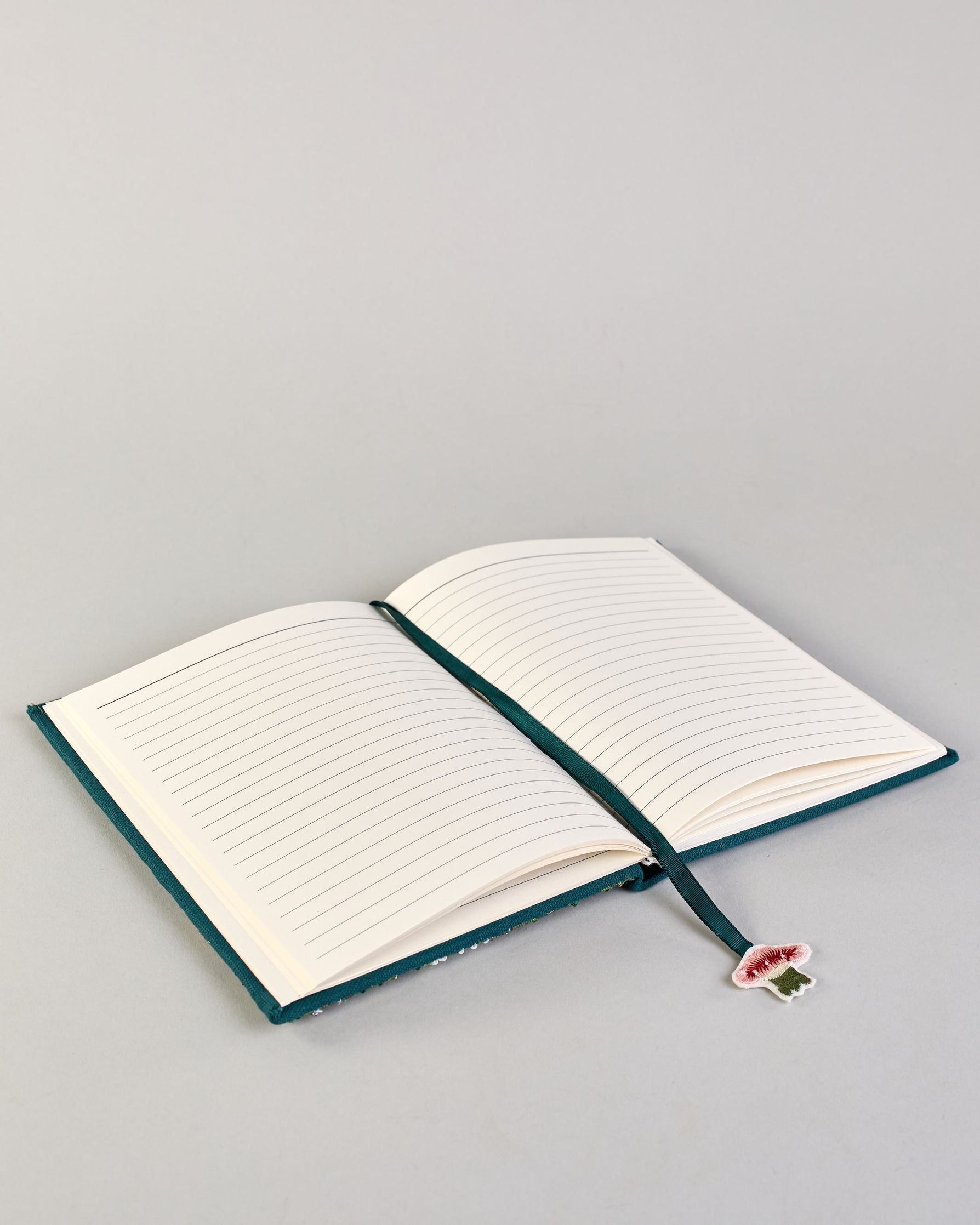 Petrolfarbenes Notizbuch mit Baumwolleinband und großem Fliegenpilz aus Perlen gestickt auf den Bucheinband, runderherum ist noch Gras aus Perlen. Lesezeichen mit Fliegenpilz als Anähnger. Linierte Seiten #5