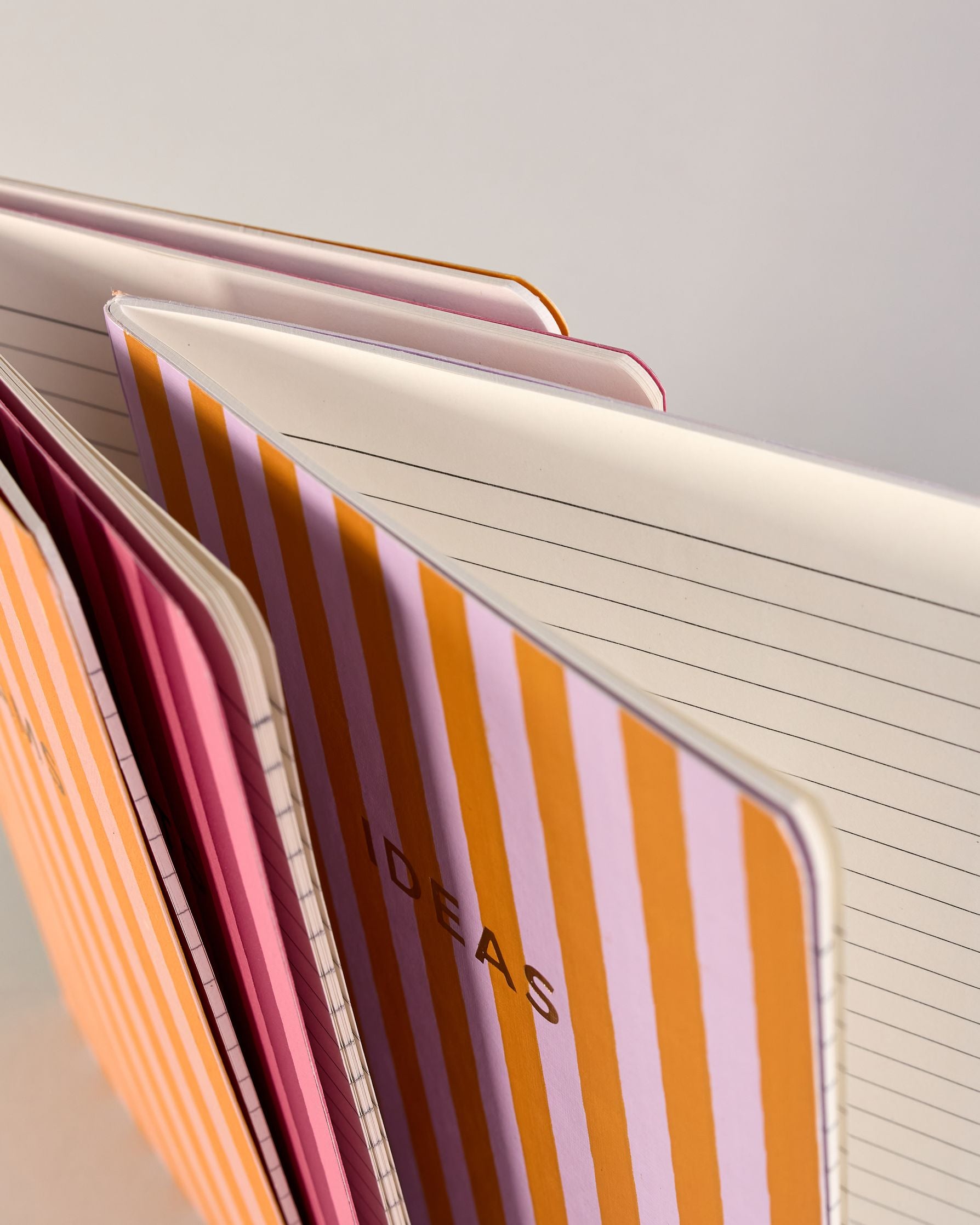 Set aus drei A5-Heften mit recyceltem Baumwolleinband. Die Hefte sind mit senkrechten Streifen in Blau- und Grüntönen gestaltet und zeigen auf dem Cover jeweils ein goldener Spruch: Dreams, Thoughts und Ideas. 30 linierte Seiten innen. #11