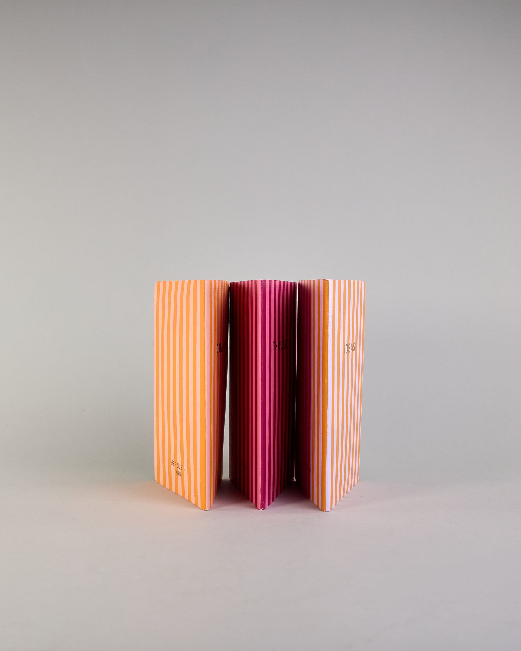 Set aus drei A5-Heften mit recyceltem Baumwolleinband. Die Hefte sind mit senkrechten Streifen in Blau- und Grüntönen gestaltet und zeigen auf dem Cover jeweils ein goldener Spruch: Dreams, Thoughts und Ideas. 30 linierte Seiten innen. #4